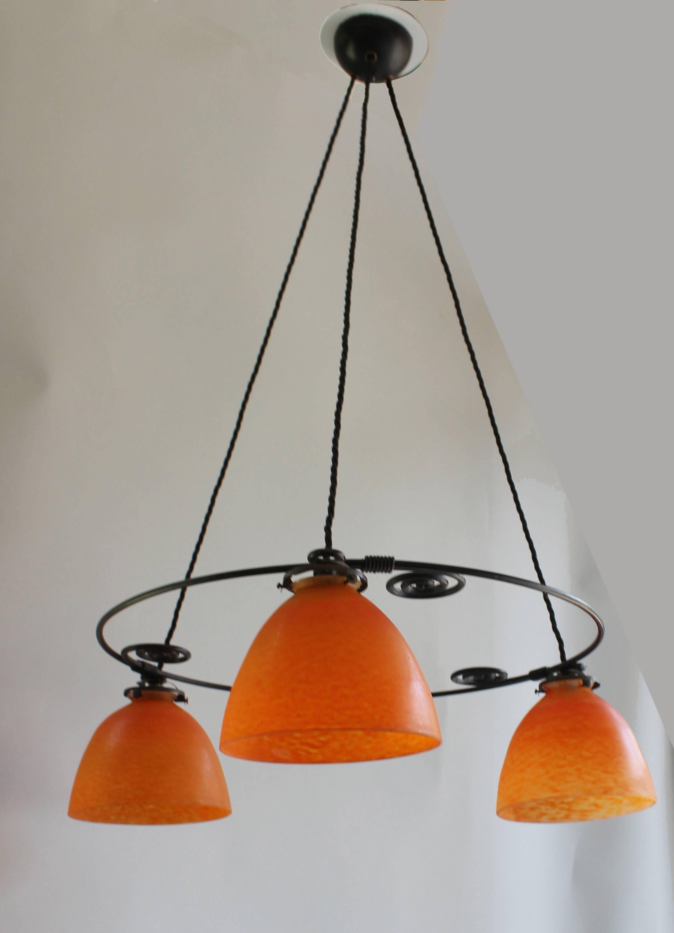 A pair of wrought iron suspensions with three orange mottled glass shades, designed by Francis Jourdain (1876-1958).
Signed "FJ" on shades.

Bibliography:
"Francis Jourdain, un parcours moderne, 1876-1958 Édition d'Art Somogy,