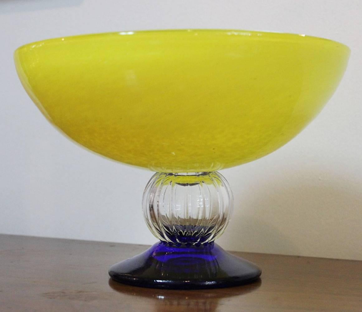 Gorgeous, mottled bright yellow bowl, with clear and purple glass pedestal base, designed by Gunnel Sahlin (Sweden, 1954) originally a textile designer, 