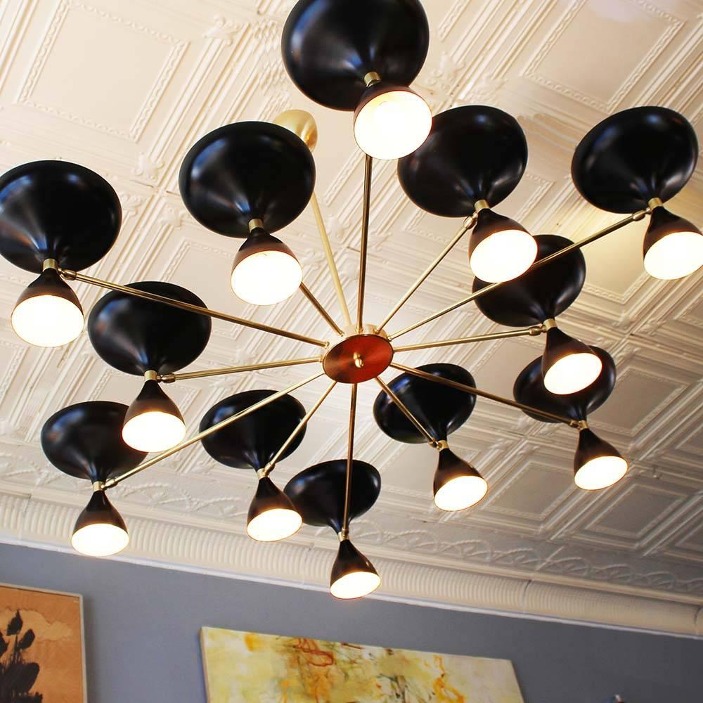 Our own exclusive sunburst design Milano chandelier, with 12 brass arms and pivoting powder coated heads with up and down sockets. In black or white, or both; nickel or brass; six-arm version also. All made in Italy.