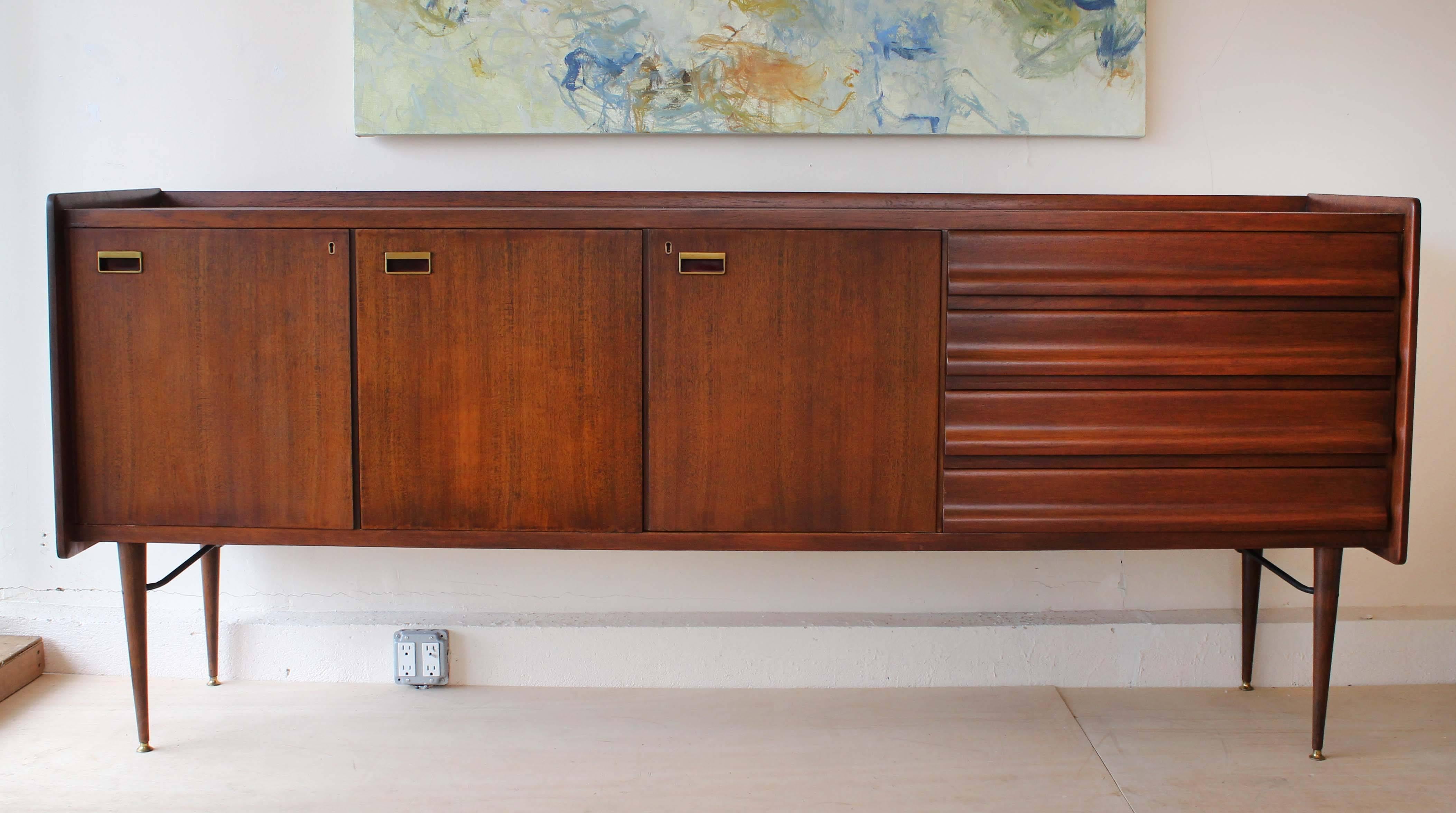 A handsome Mid-Century Italian wood sideboard with brass and enameled metal hardware.
