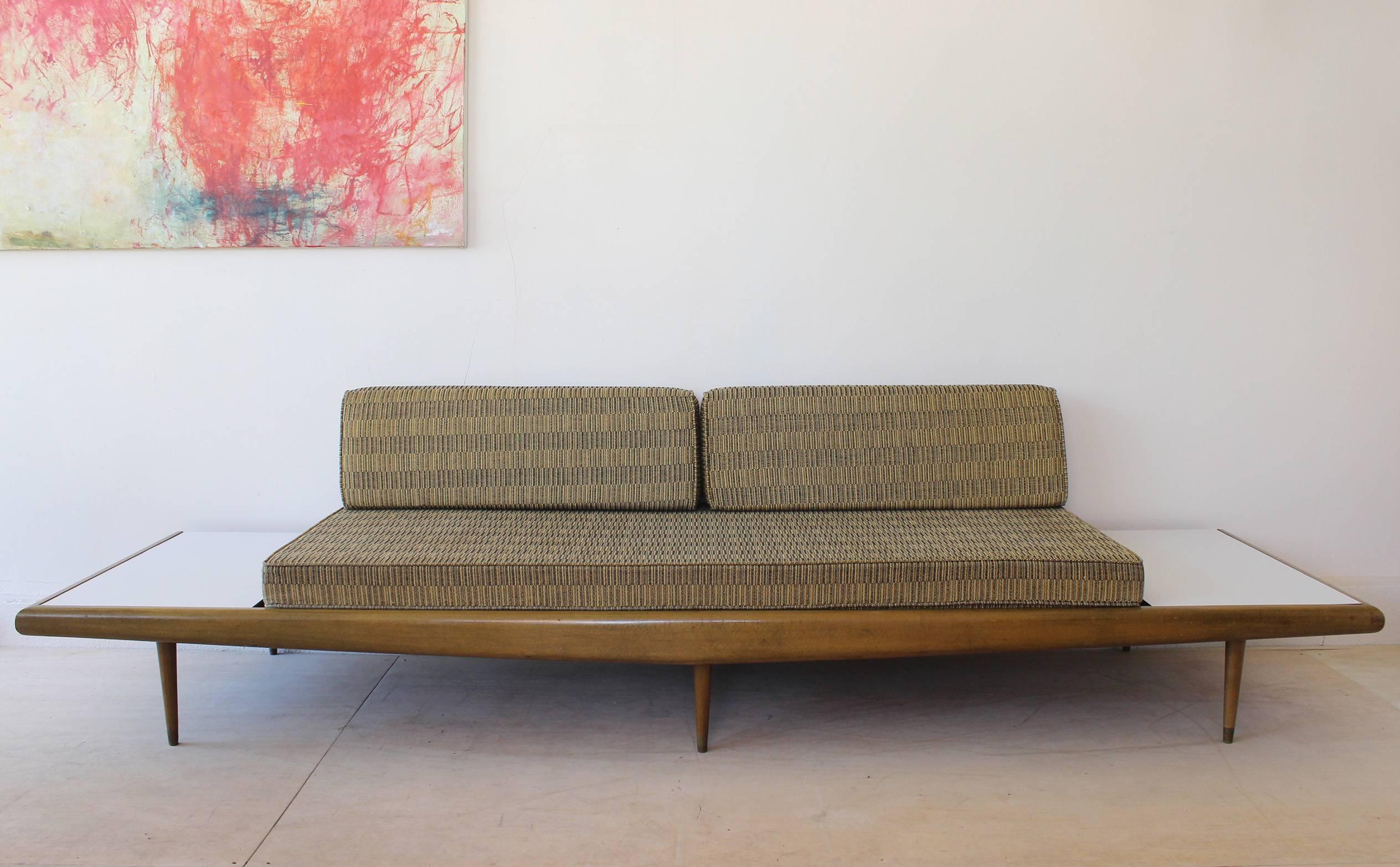 A walnut frame sofa daybed bench in the manner of Adrian Pearsall, with original cushions and bolsters, Formica and brass details.