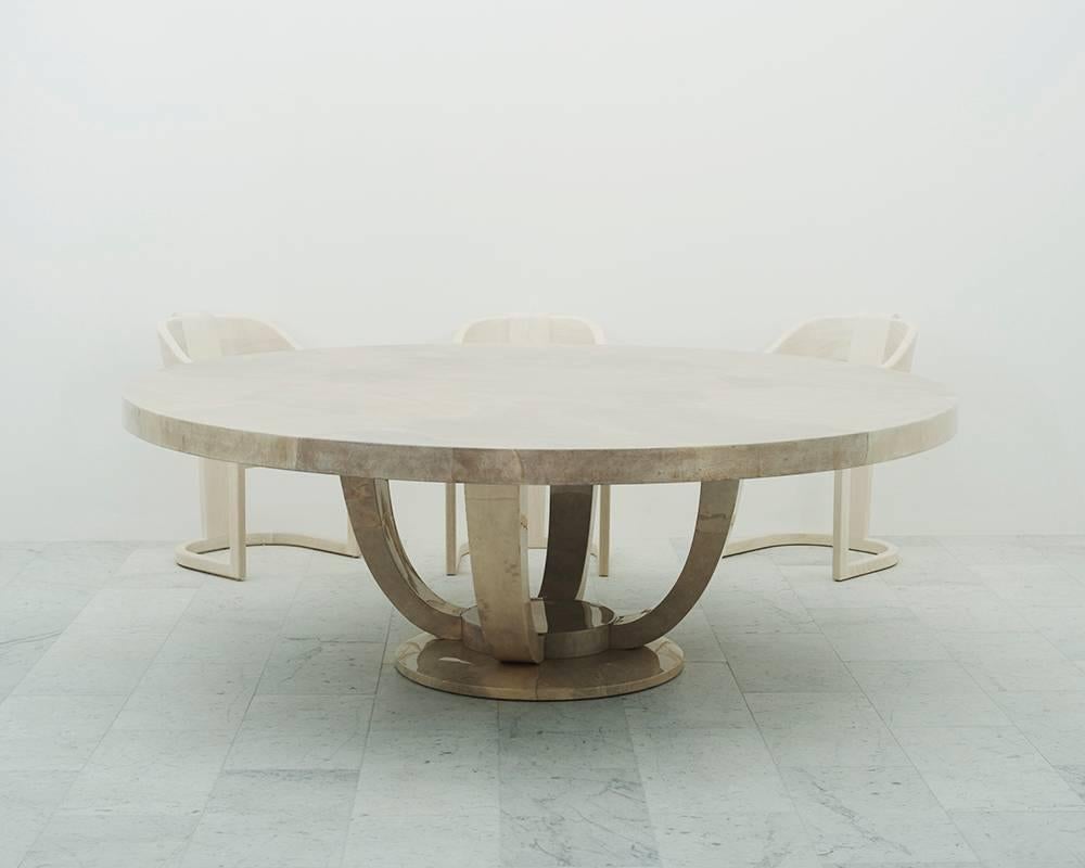 An exquisite dining table made of free-form in lay natural goatskin in warm pearl grey. The table is finished in a polished lacquer. Featuring Classic Art Deco lines, the round base that blossoms four supports beneath a monumental 8 foot circular