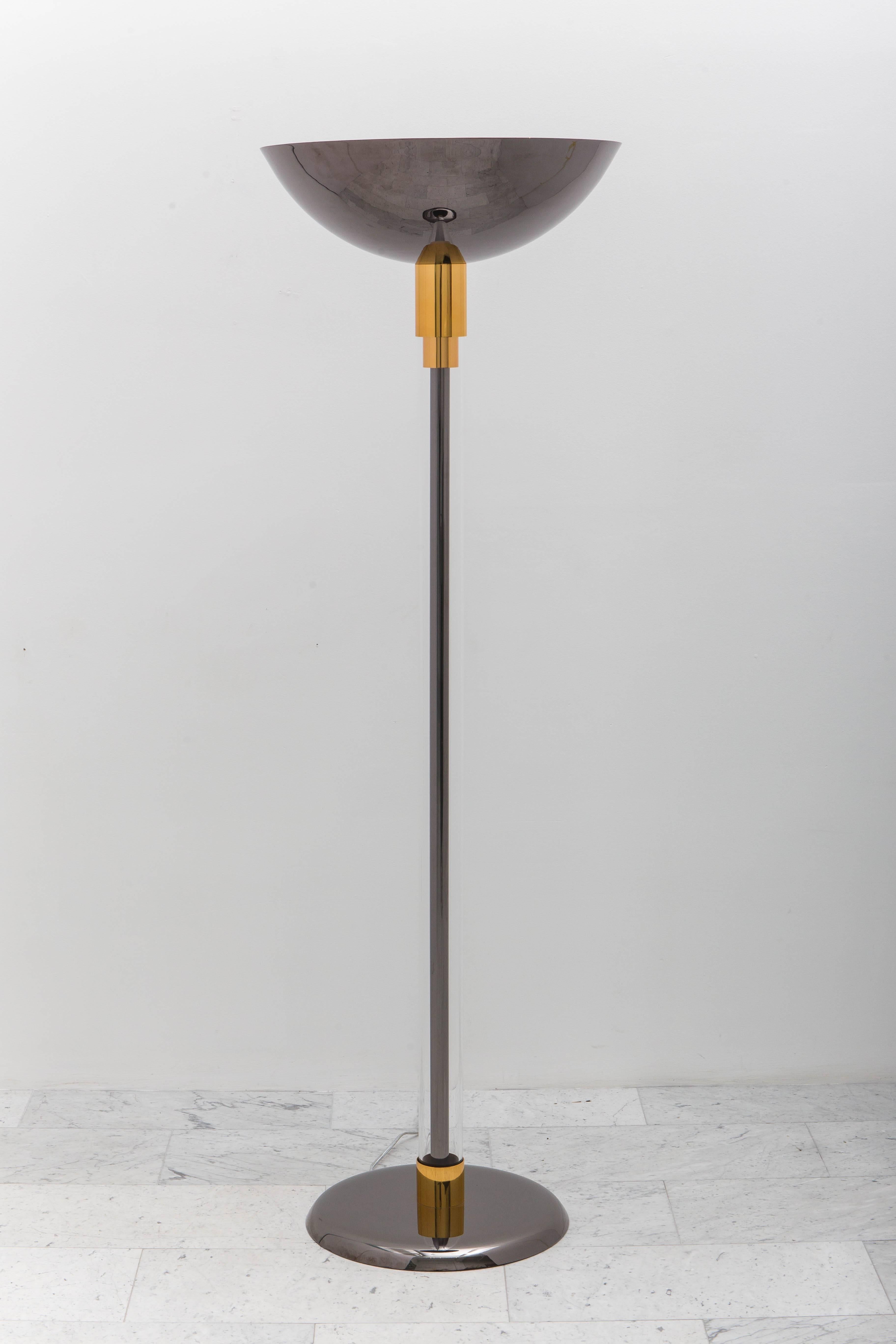 A pair of large torchieres (Torchiere #3) by Karl Springer finished in a sophisticated pairing of metals – Architectural polished gold-bronze and gunmetal. Each lamp features a gunmetal stem housed within a lucite cylindrical body supporting a 22″