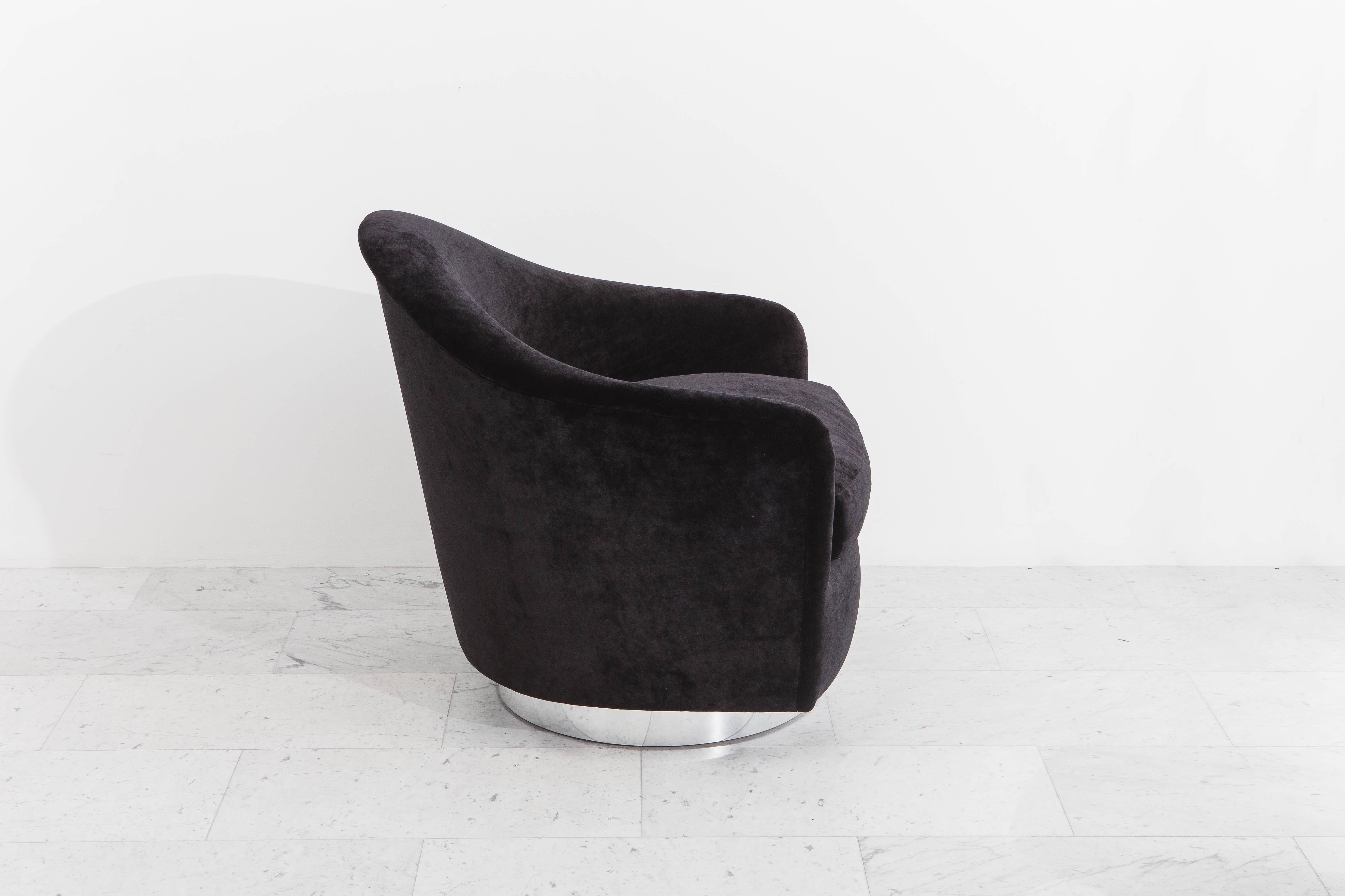 A beautiful single swivel chair designed by Milo Baughman with a circular chrome base and matching ottoman. The combination of high back and foot rest offers an ideal seating option for a single comfortable accent chair. Newly upholstered in a
