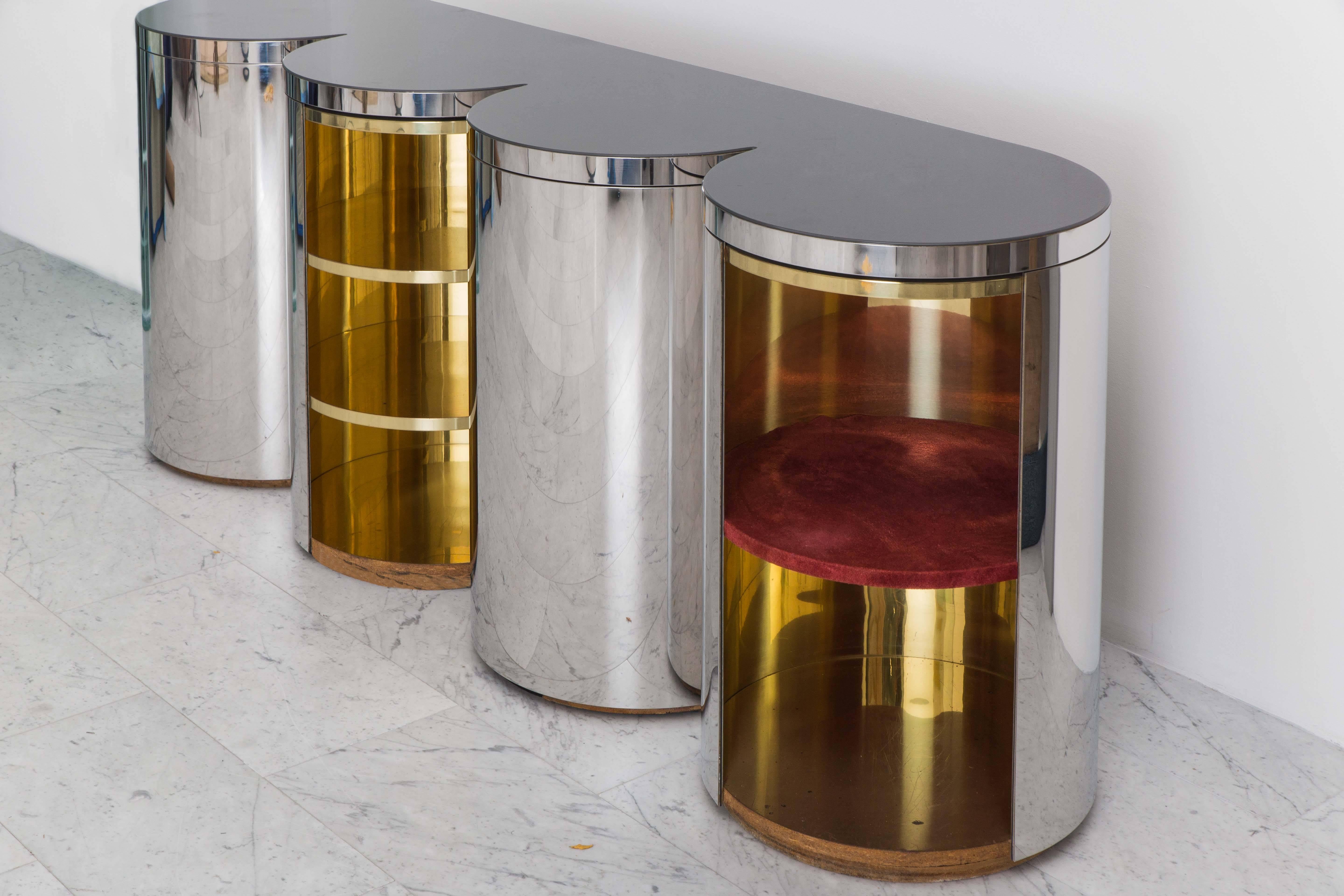 A mirror polished steel cylindrical credenza designed in 1981 by Paul Evans for the Paul Evans Showroom in New York, the credenza features a unique design with ample storage space. Made with plexiglass, wood, and laminated interiors, the cylindrical