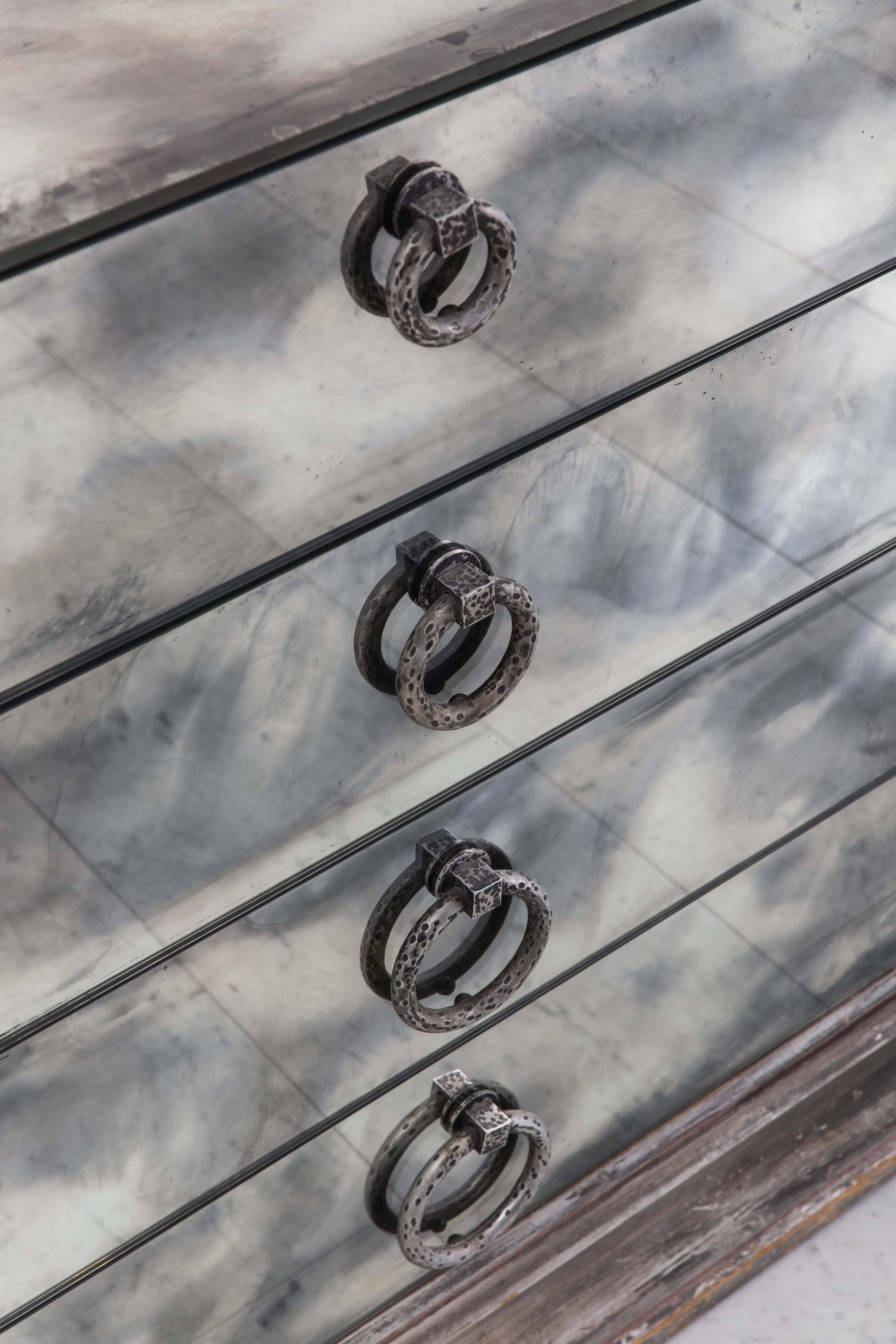 This glittering Hollywood Regency breakfront sideboard by James Mont features a smoked mirror top and front, set inside a hand-carved, deeply beveled, silver leafed and burnished frame. Featuring four drawers and two cabinets with dappled silver
