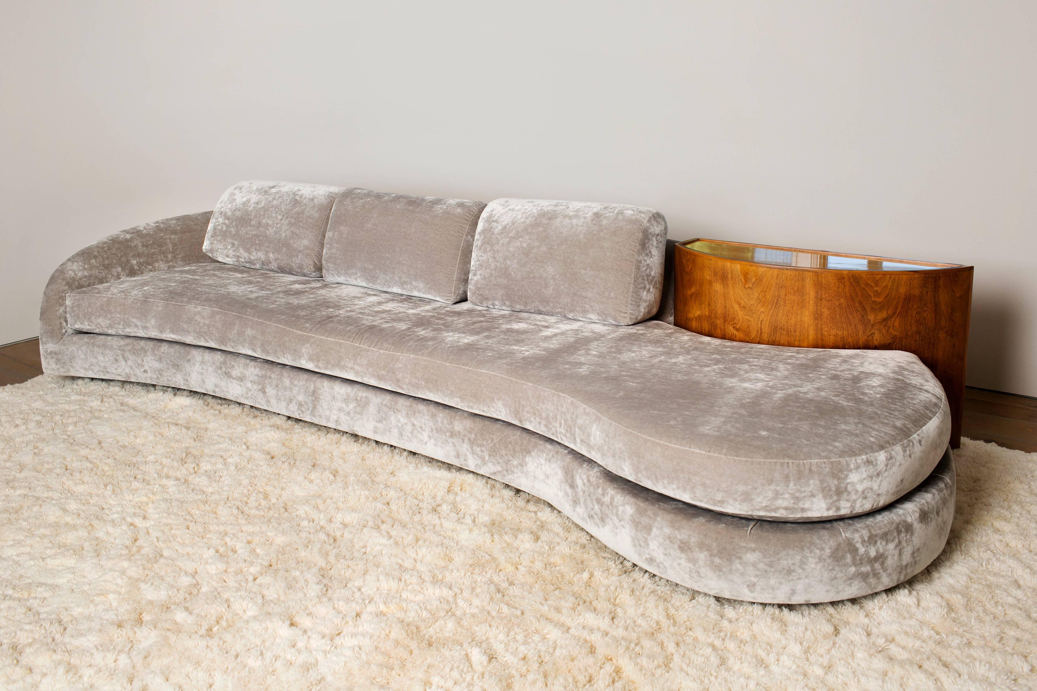 Designed in the 1970s, the Serpentine Sofa with Demi-Lune Table is similar in style to the designs of Vladimir Kagan. Elegant and sleek, the sofa has been reupholstered in a luxurious velvet. The sofa is additionally fitted with a demi-lune table of