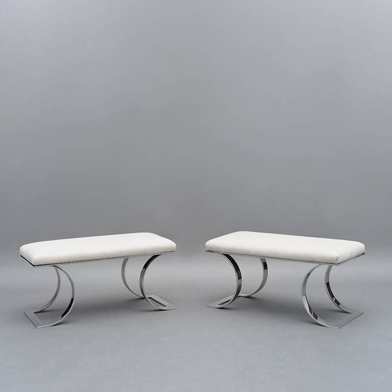 This exquisite pair of Jean-Michel Frank inspired “C” benches designed and made by Karl Springer feature elegant curved polished stainless steel legs and newly upholstered parchment leather seat cushions. The benches were acquired directly from Karl