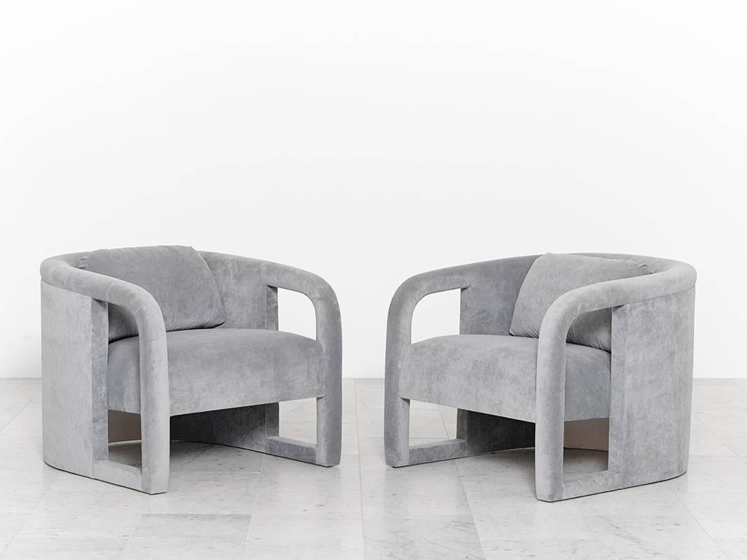 A pair of elegantly curved club chairs designed by Milo Baughman; each chair features a removable back cushion for extra support. The chairs have been newly upholstered in a beautiful ash grey velvet and are in excellent, newly restored