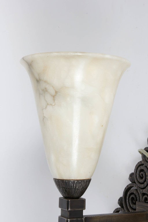 Edgar Brandt pair of wrought iron and alabaster wall sconces. Signed E. Brandt.
Alabaster shades are old but may not be original.