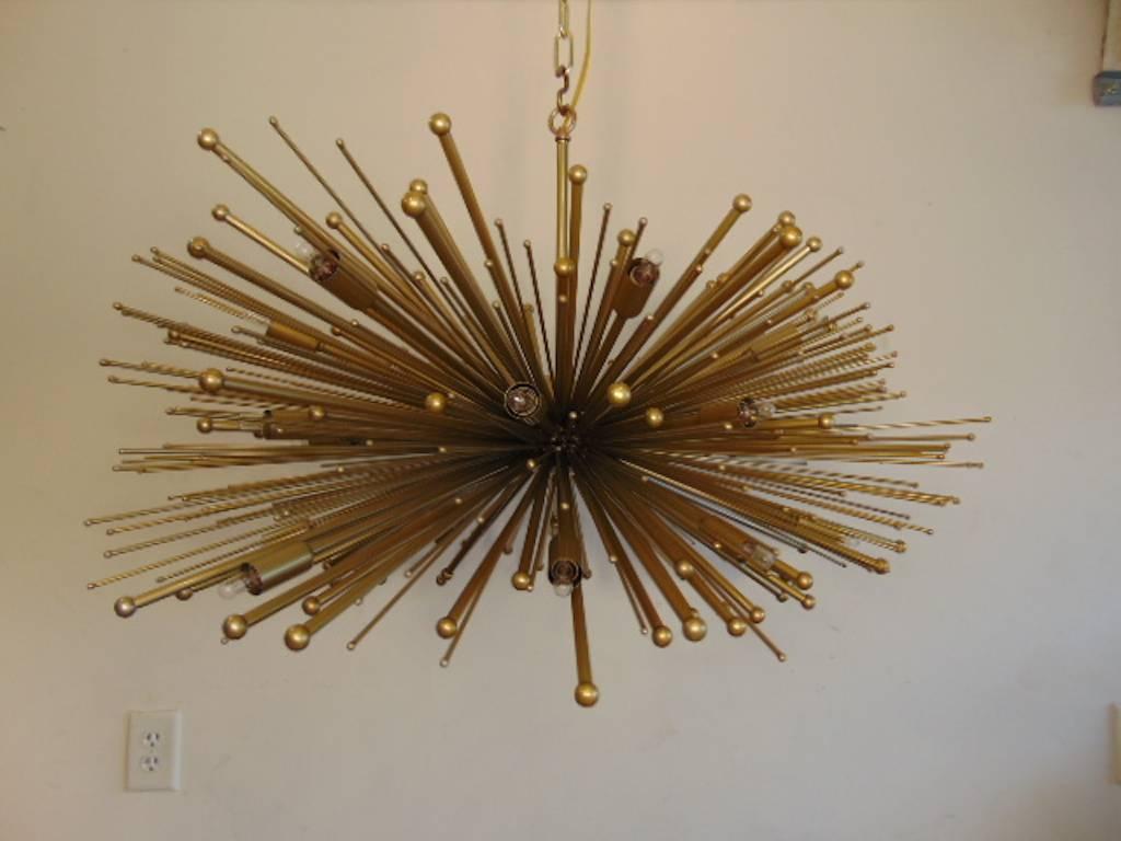 An oval supernova with a gold finish and bronze accents. These chandeliers can come in any custom size and color finish.