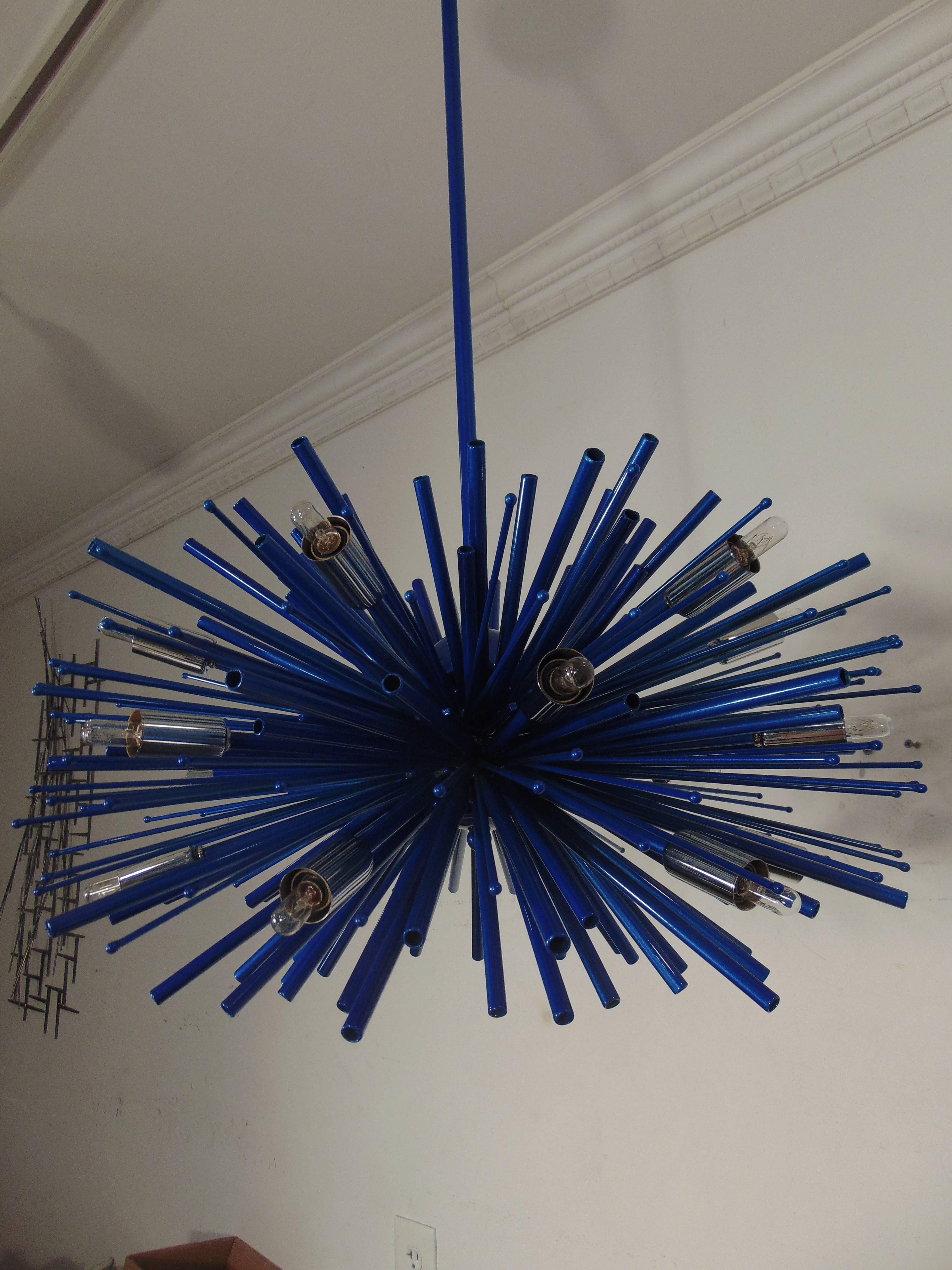 A supernova chandelier with eighteen lights by Lou Blass. 24 inch diameter with Blue-Berg finish.
  
  