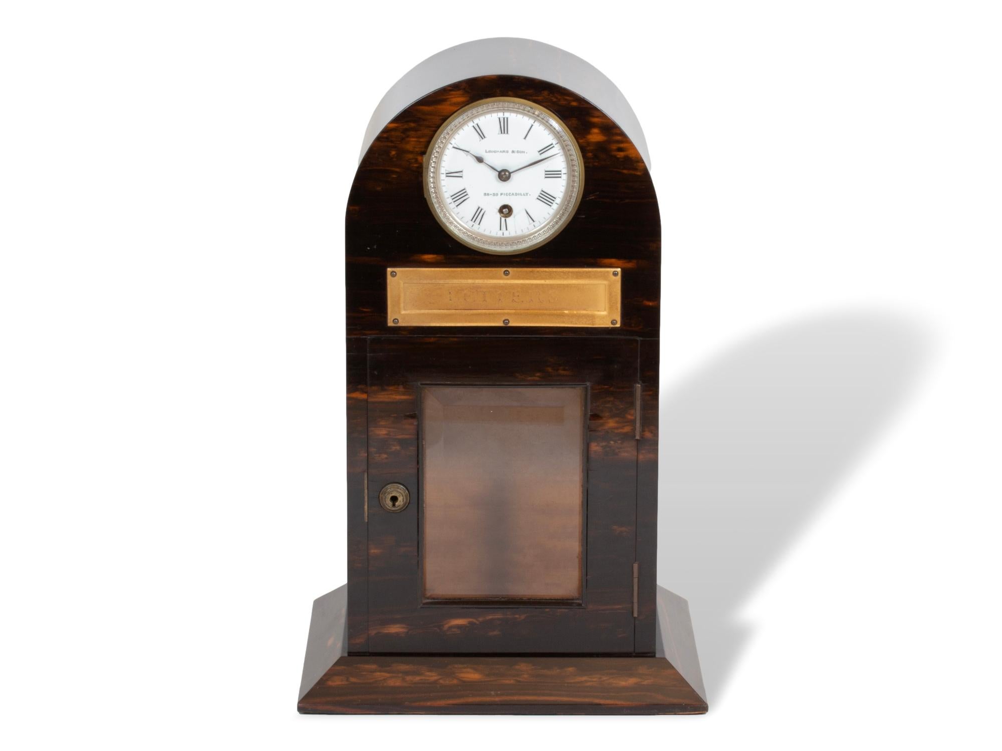 Prodotto da Chapman e venduto da Leuchars

Dalla nostra collezione di scatole, siamo lieti di presentare questo rarissimo Coromandel Letter Box Clock di Chapman, venduto da Leuchars. La cassetta per le lettere poggia su una base a plinto con corpo