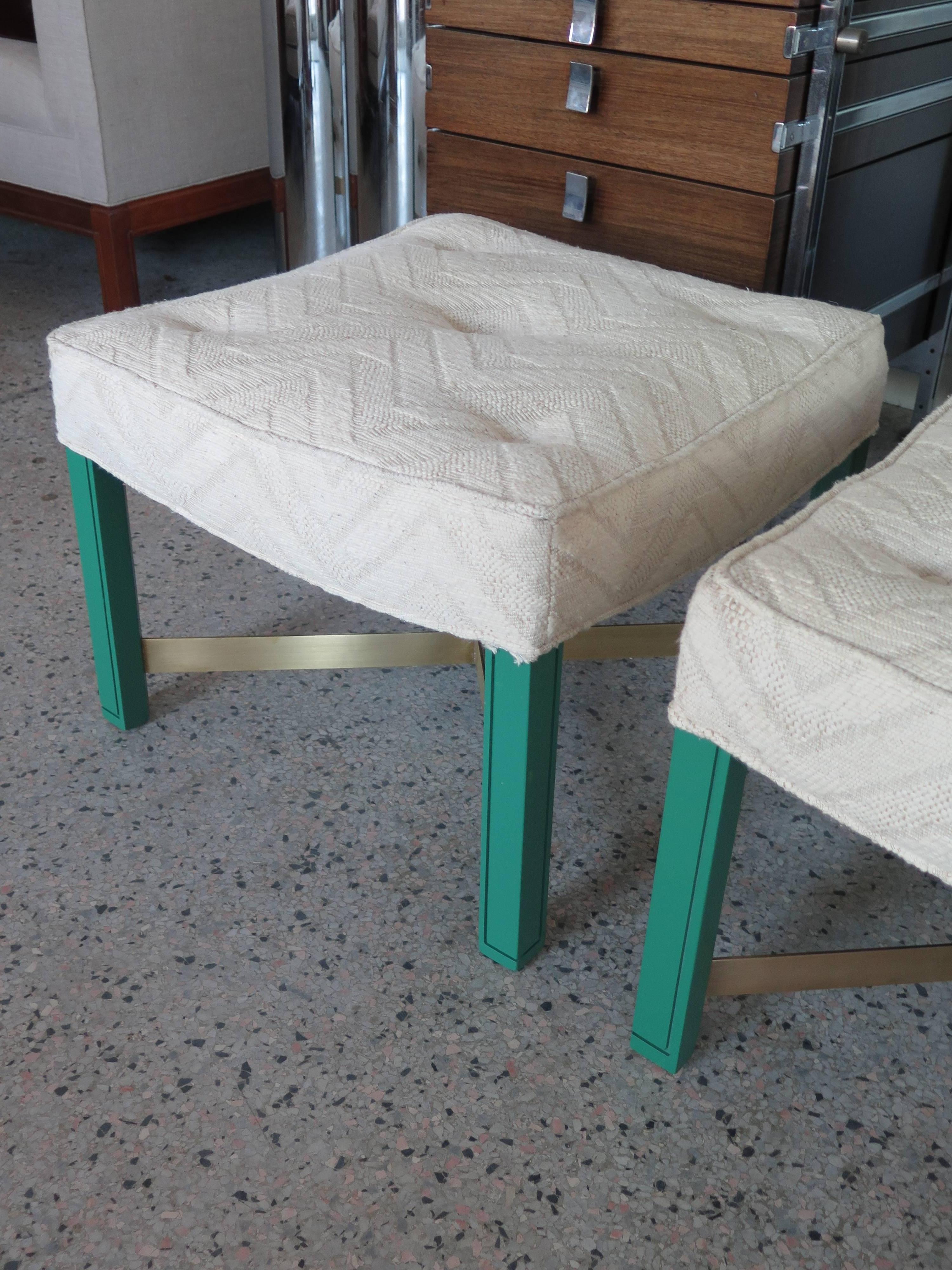A pair of Paul Laszlo ottomans. Green laquered notched legs with brass cross stretchers.
