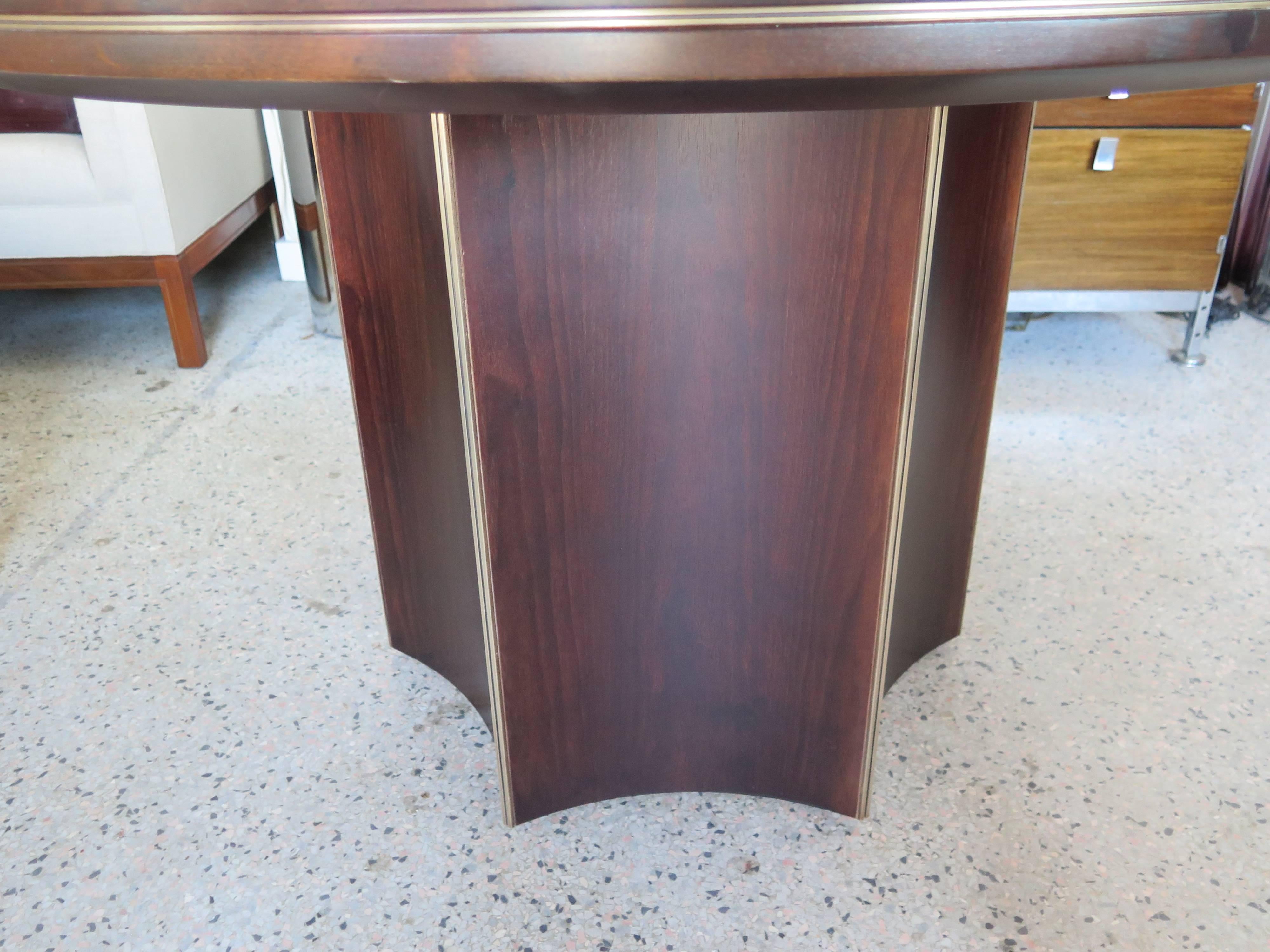 An unusual center table by McGuire of San Francisco. Six sided base with brass details and also on the top. Quality mahogany construction with nice graining, restored.