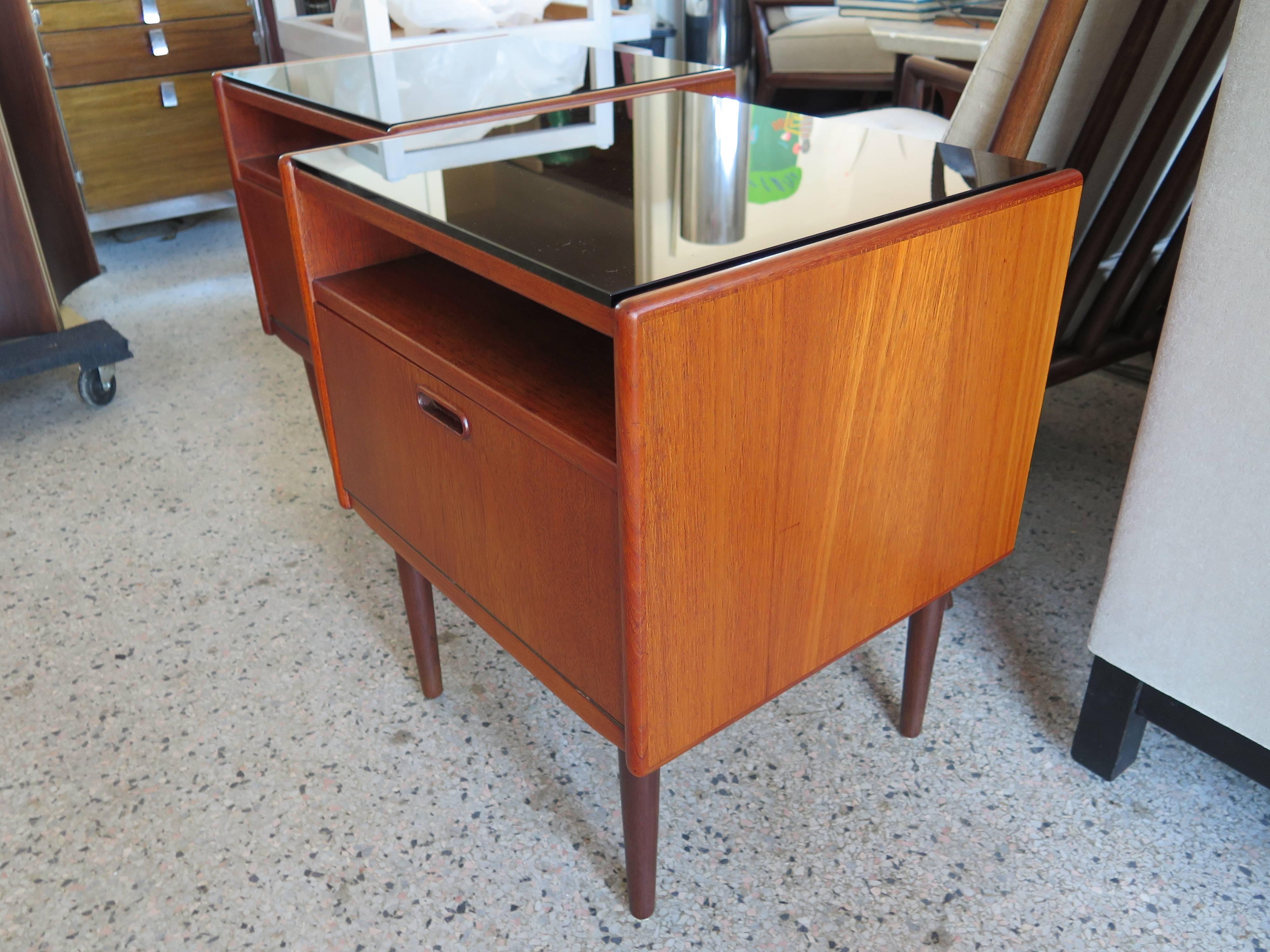 A pair of Classic night stands by Borge Mogensen for Soborg Mobler, Denmark, circa 1960s. Teak with white laminate drop fronts and glass tops. Open shelf above drop front for extra storage.