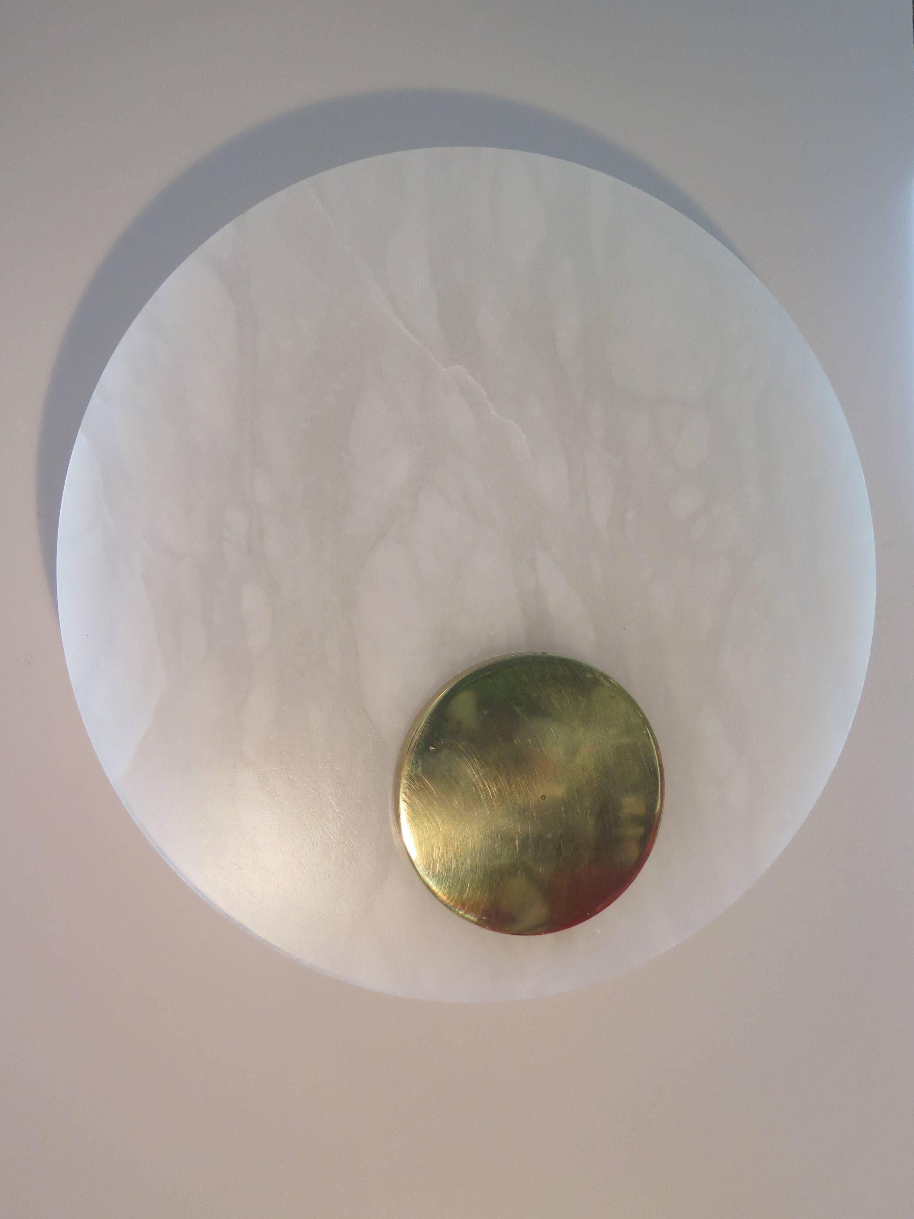 A set of three unusual alabaster and polished brass sconces by Lightolier (signed). Simple geometric design-circle in a circle, glass diffuser.