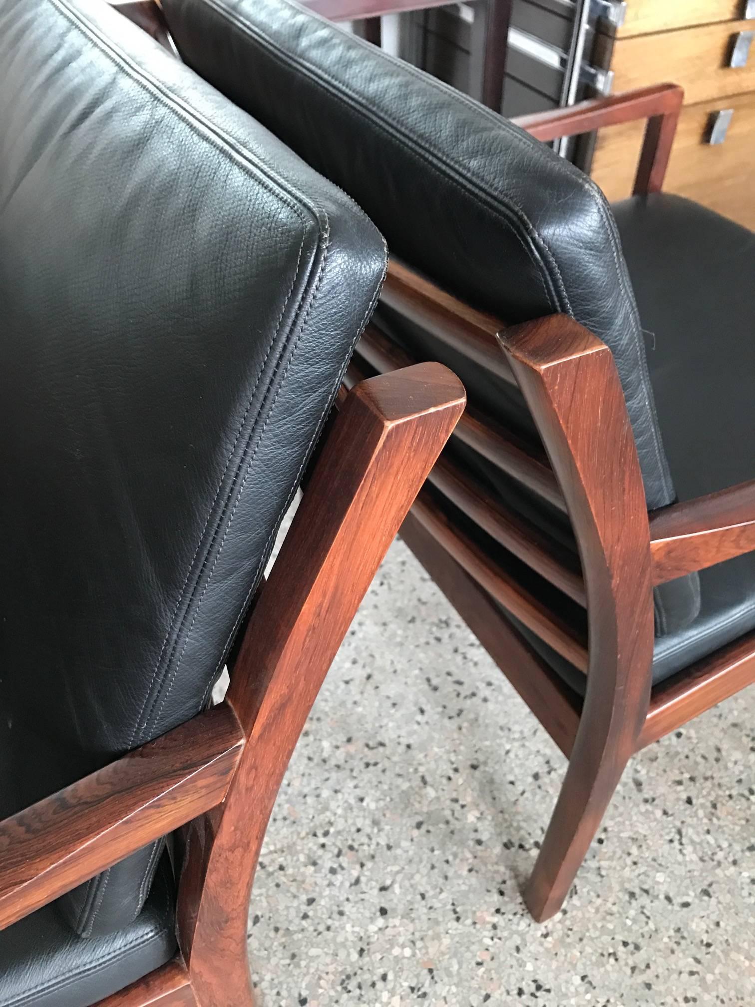 Une paire d'excellentes chaises modèle-806 par Fredrik Kayser pour Vatne, Norvège, 1967. Bois de rose (palissandre) avec revêtement d'origine en similicuir noir. Importé pour Carson Pirie Scott, célèbre détaillant de Chicago opérant dans l'immeuble