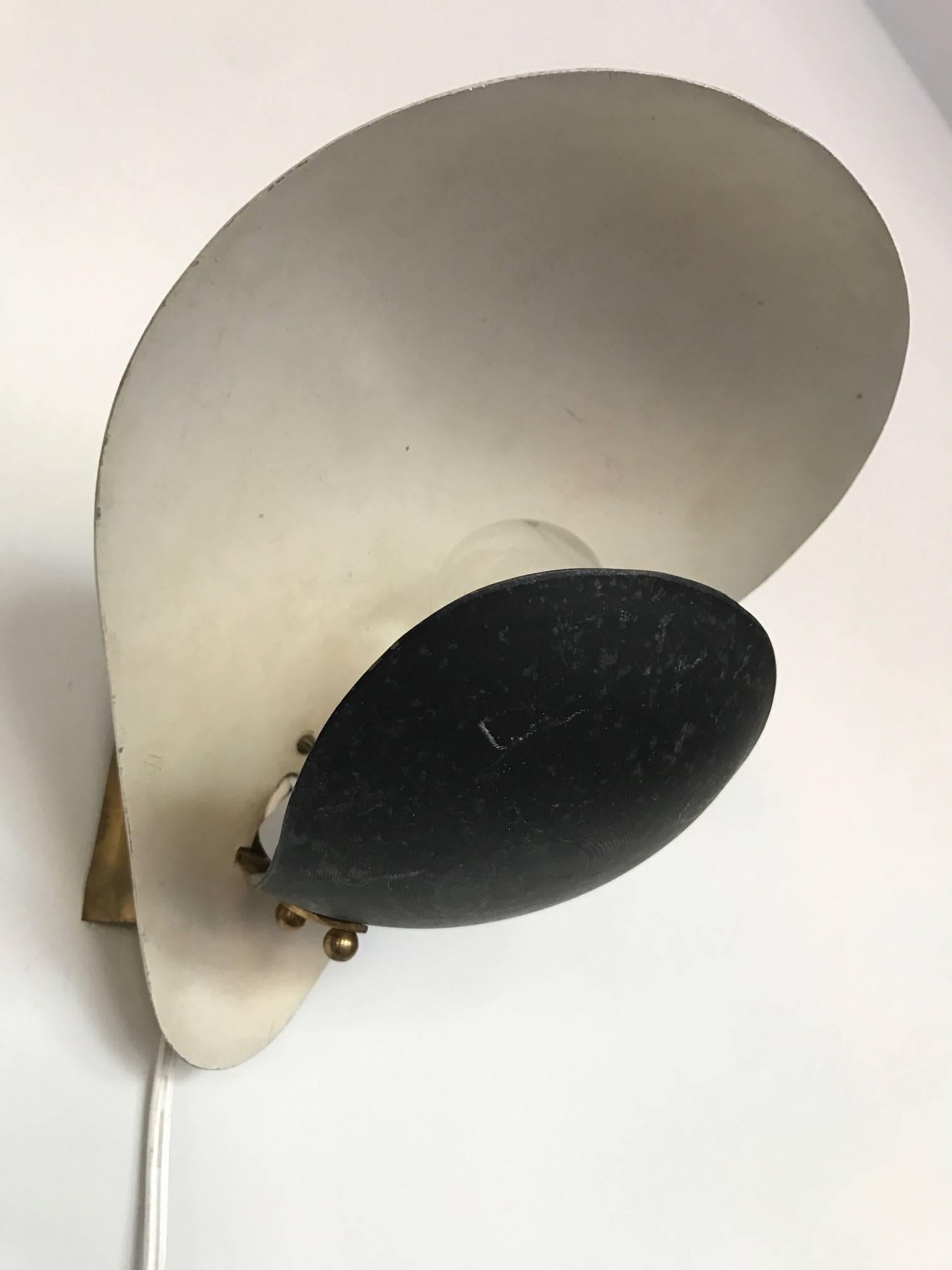 A pair of modernist Italian sconces (appliques). Unusual black and white shapes that pivot, allowing for lights to be hung in many ways. And angle out or towards the wall. Original paint. Brass fittings.