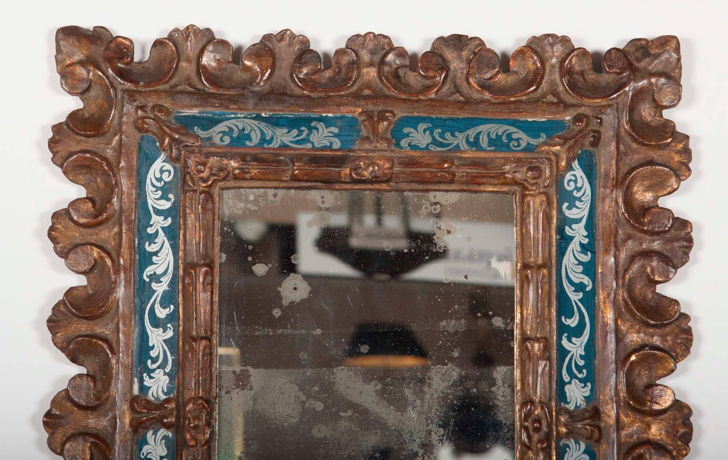 A Venetian carved gilt wood frame with silver and blue vere églomisé panels and original antique looking glass.