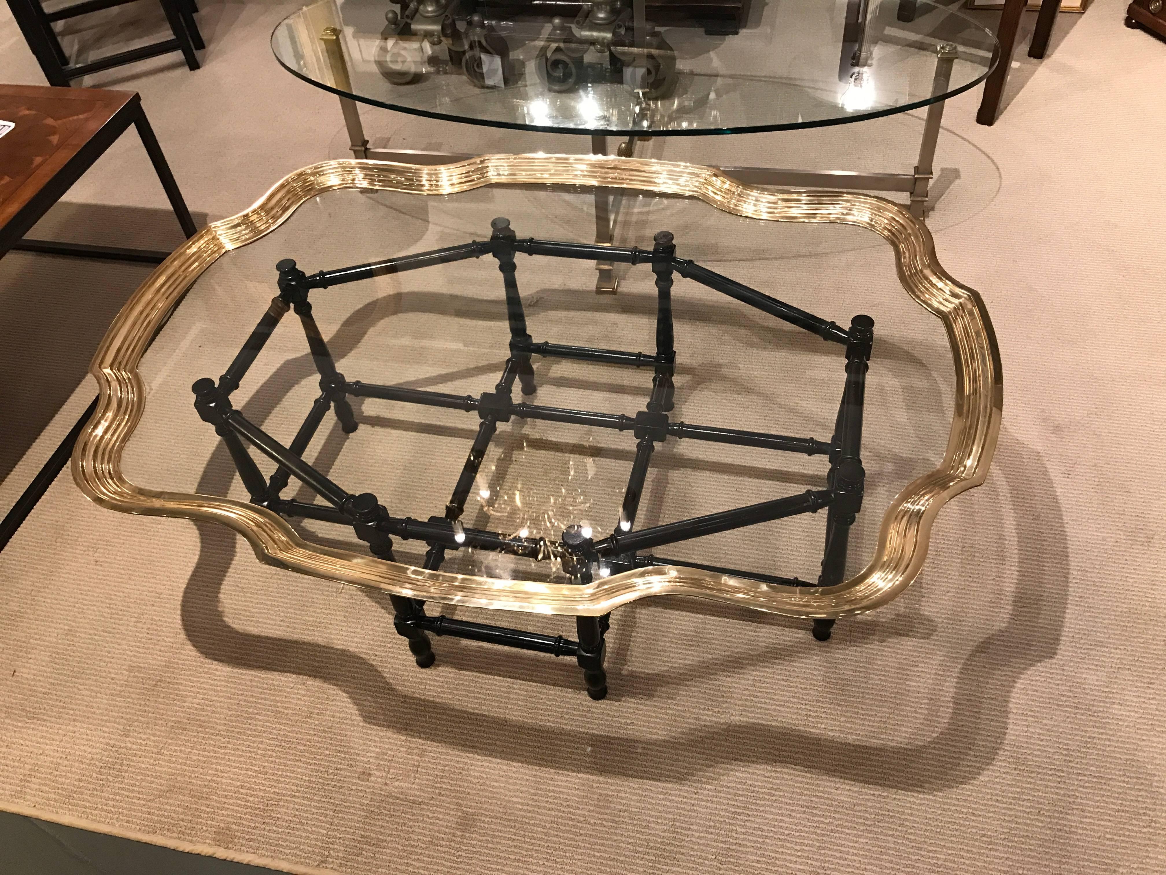 Vintage Baker coffee table, the glass top with an elaborate pie-crust brass edge on an ebonized faux bamboo wood stand. In the Regency style, an elegant modern interpretation of the antique. 