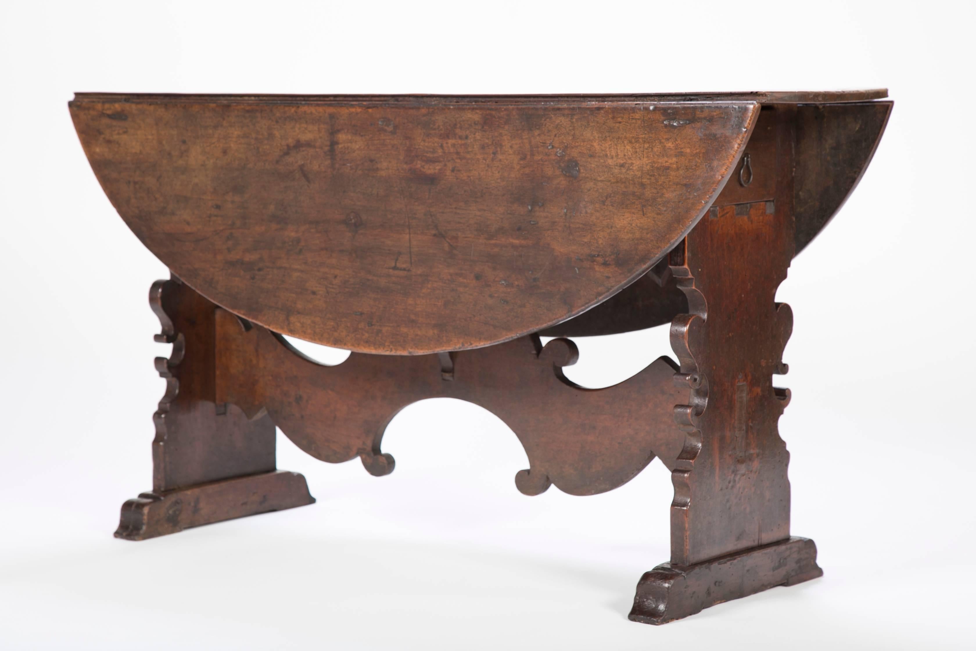 Best quality 16th-17th century Italian walnut table with a rich honey patina. The end profiles and trestle base are the epitome of the Baroque. This table will make a unique breakfast or sofa table for any style interior. Drawers at either