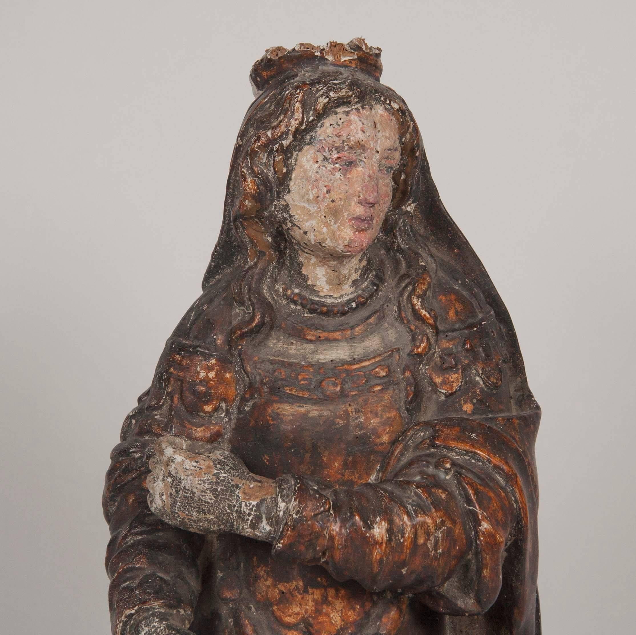 Italian carved and polychromed figure of a female saint. She is missing her attribute which she would have been holding in her hands, and is wearing a crown on her head, mid-16th century. Though the surface is worn from age, it retains some of its