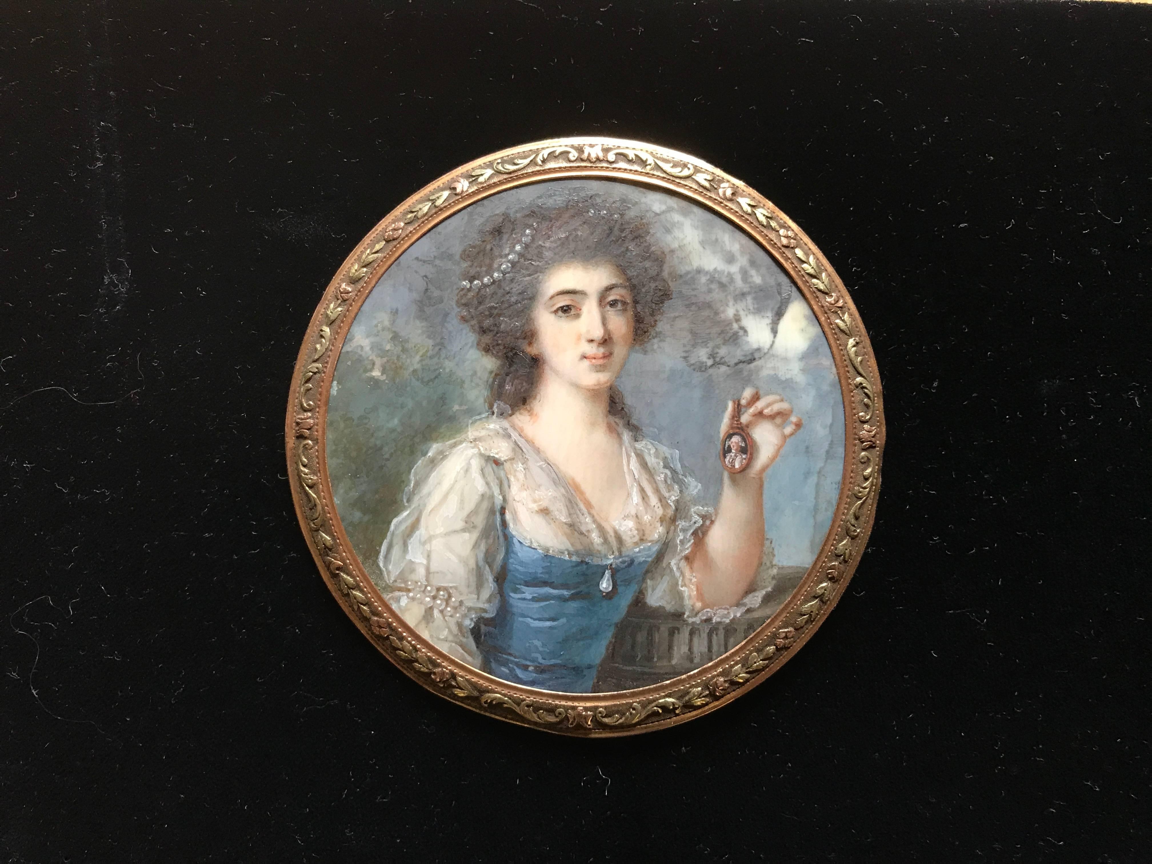 Very fine early 18th century English portrait miniature of an attractive, possibly royal, woman. An utterly charming portrait of a woman from noble background wearing a silk gown and pearls. In an amusing twist she is holding a portrait miniature of
