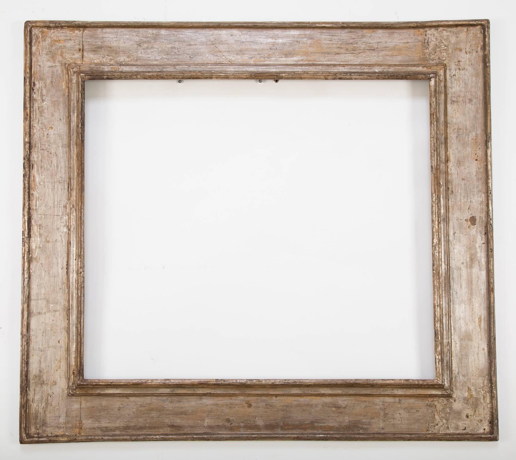 An Italian Baroque period frame, originally made for an Old Master painting, now holding a beveled glass mirror. The wide Roman molding and original silver gilding give the frame a contemporary feel. Great for both an antique and modern