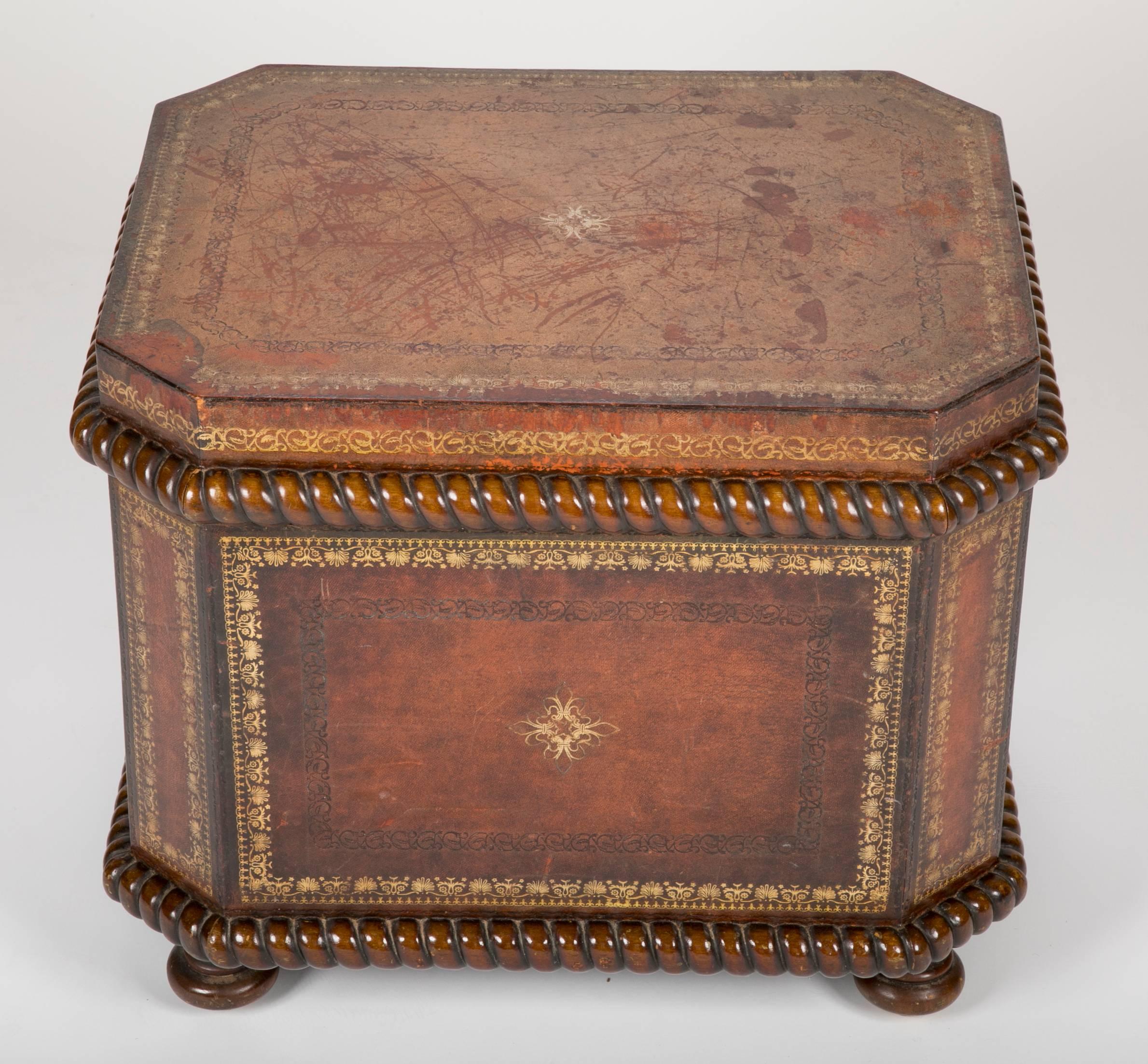 French leather and walnut chest or ottoman, with tooled and gilt decoration. The interior lined with faux marble paper. The leather surface distressed throughout adding a real charm to this handsome piece.