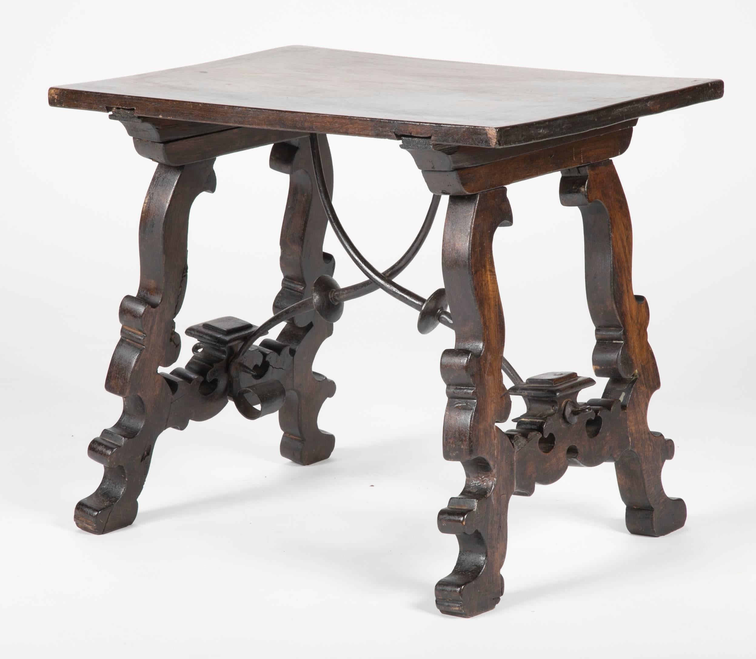 A lovely Spanish walnut side table with exceptional carving to the legs, joined by wrought iron stretchers typical of the Baroque style. A side or end table with real presence.