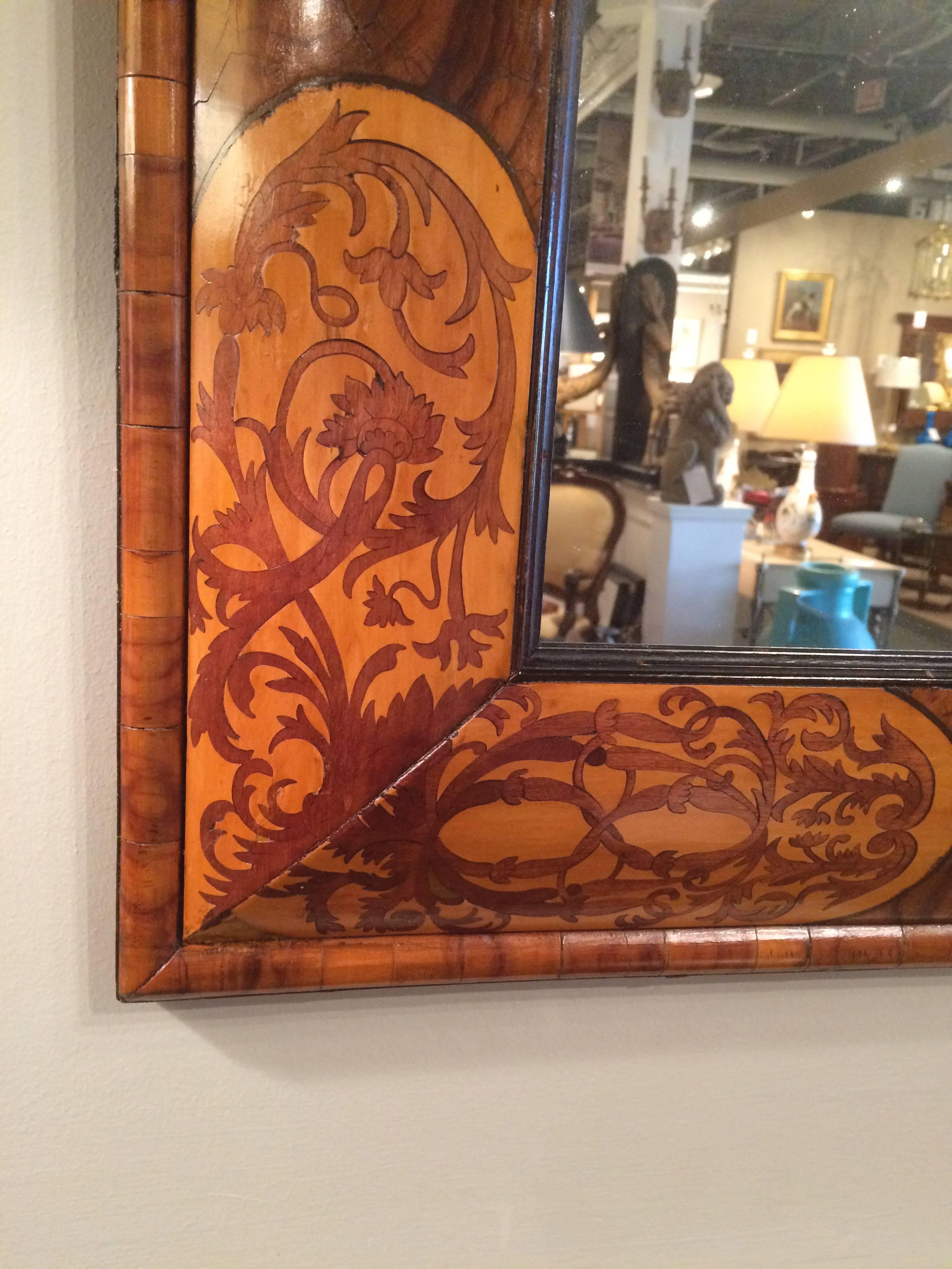 Beautiful cushion-form mirror frame with detailed fruitwood marquetry inlay on the four corners and exquisite oyster veneer.