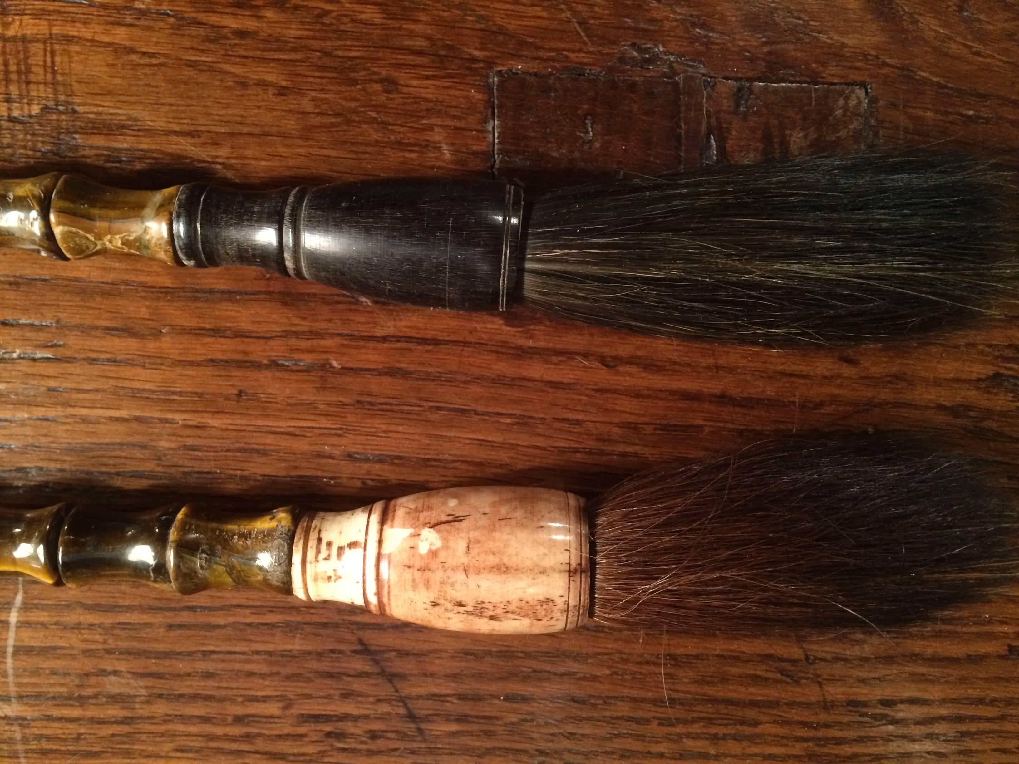 Group of four Chinese calligraphy brushes, two of polished bone and red coral, one of bone and tigers eye and one of ebony and tigers eye. All with horse hair brushes.
12 inches the longest, brush included.