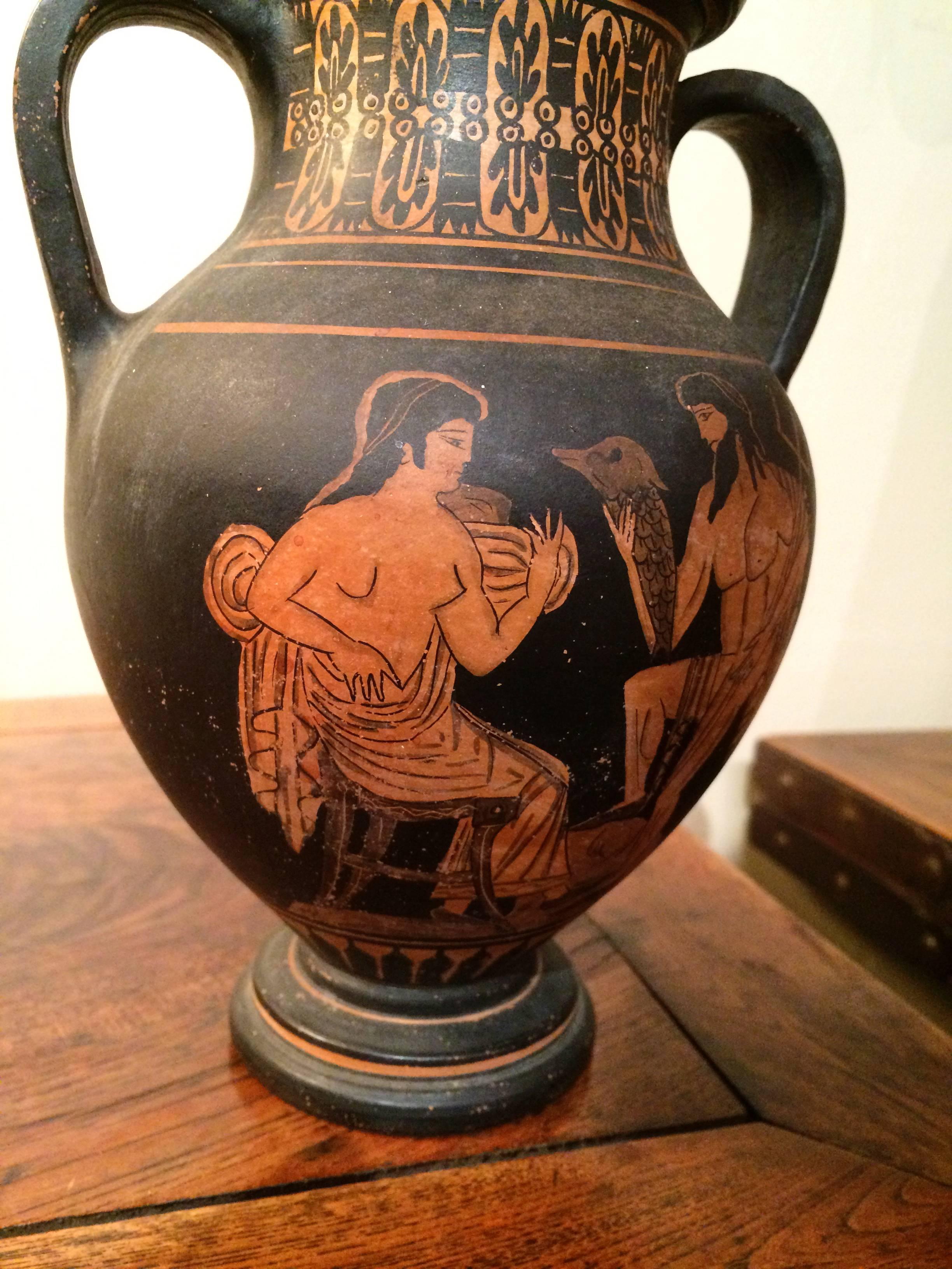 Classical Greek two handled vase in the ancient style depicting a mythological scene with Neptune presenting a porpoise to a seated woman or goddess. 