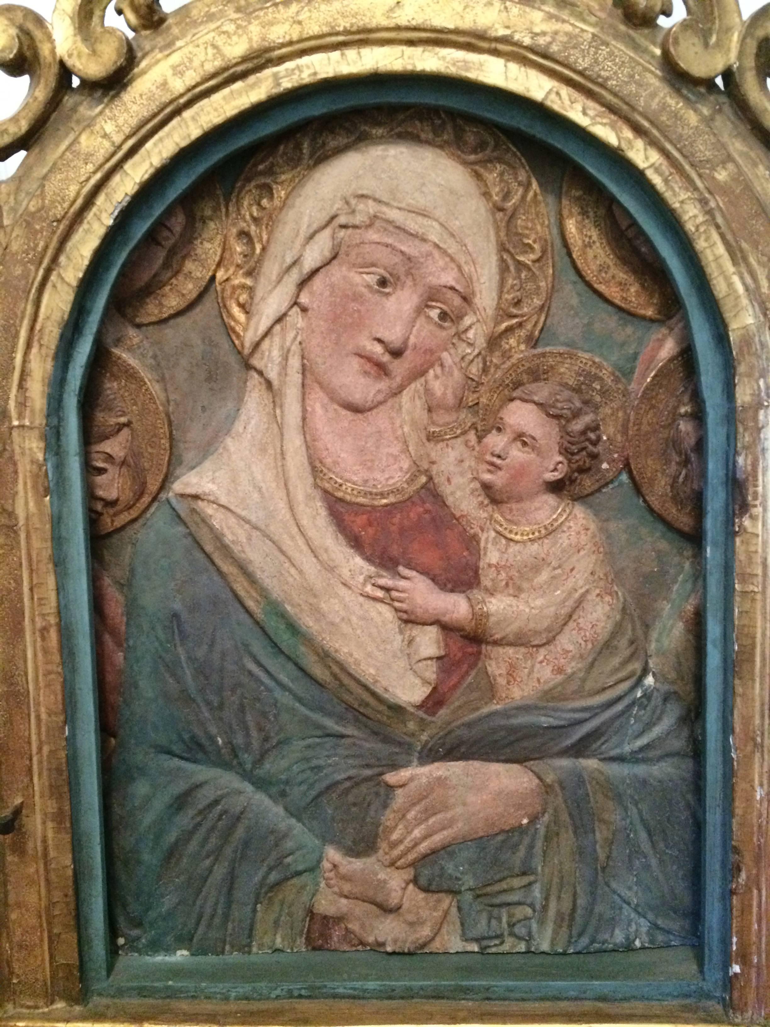 Rare Florentine 15th century stucco relief of the Madonna and Child shown surrounded by angels. With original paint set into a 17th century Italian Baroque giltwood frame.