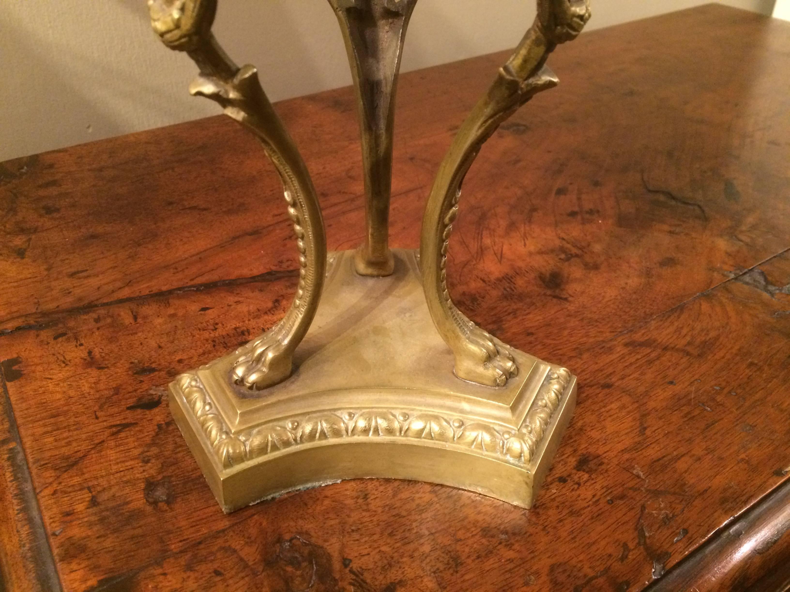 An Italian neoclassical style bronze tripod stand with three paw-footed winged female angel supports holding a marble orb.