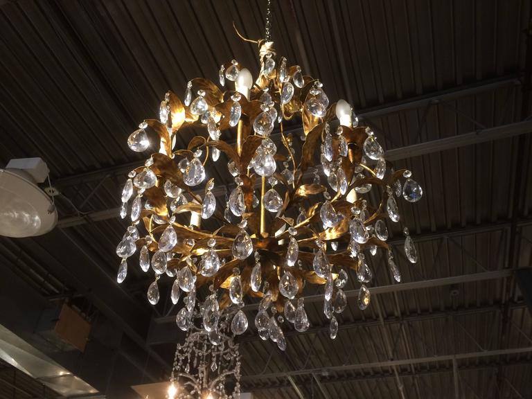 Medium scale French Baguès style six-light chandelier with gilt metal stem and leaf structure and cut crystals.