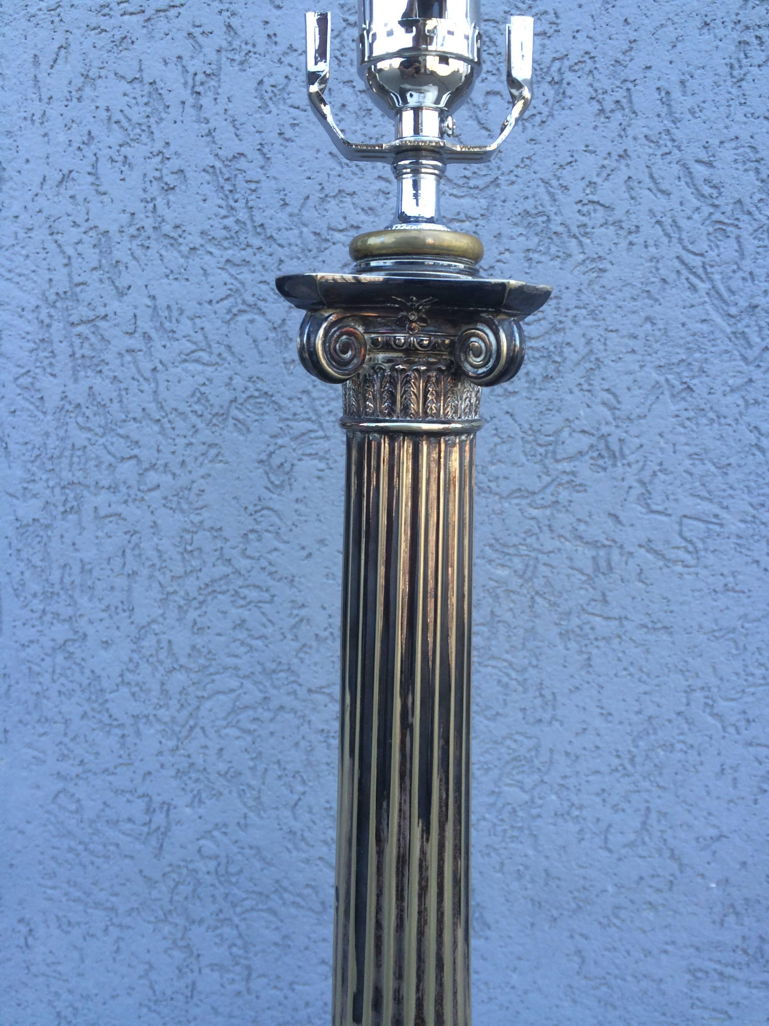 Belle lampe de table néoclassique de style Régence anglaise en métal argenté, à base étagée et chapiteau corinthien. La base est ornée de couronnes décoratives, dont l'une est gravée de deux lions rampants.