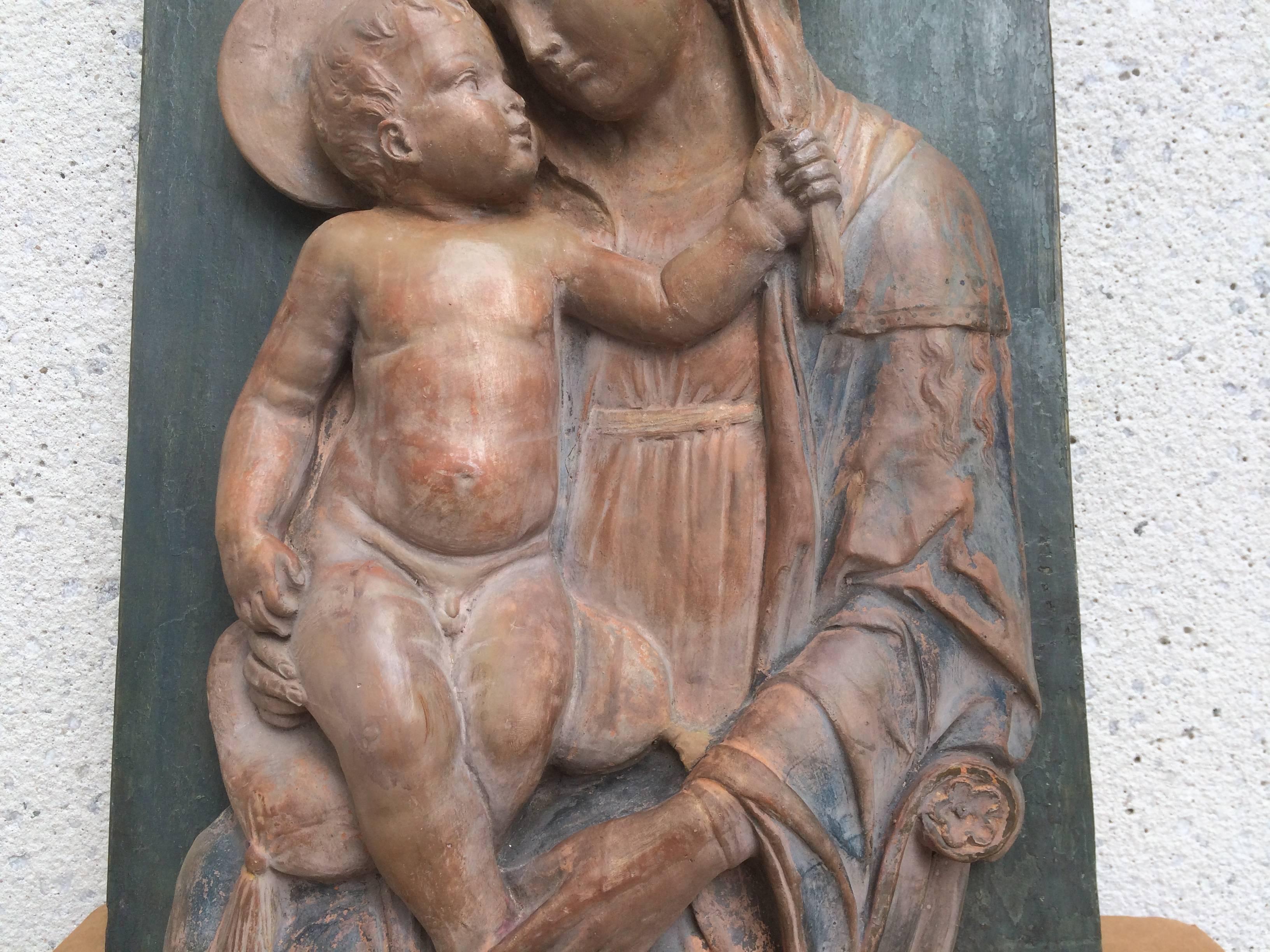 Terracotta relief of the Madonna and Child with traces of original polychrome mounted on on a blue painted board. This charming version is in the 15th century Renaissance style, after Andrea della Robbia. Florence, mid-19th century.