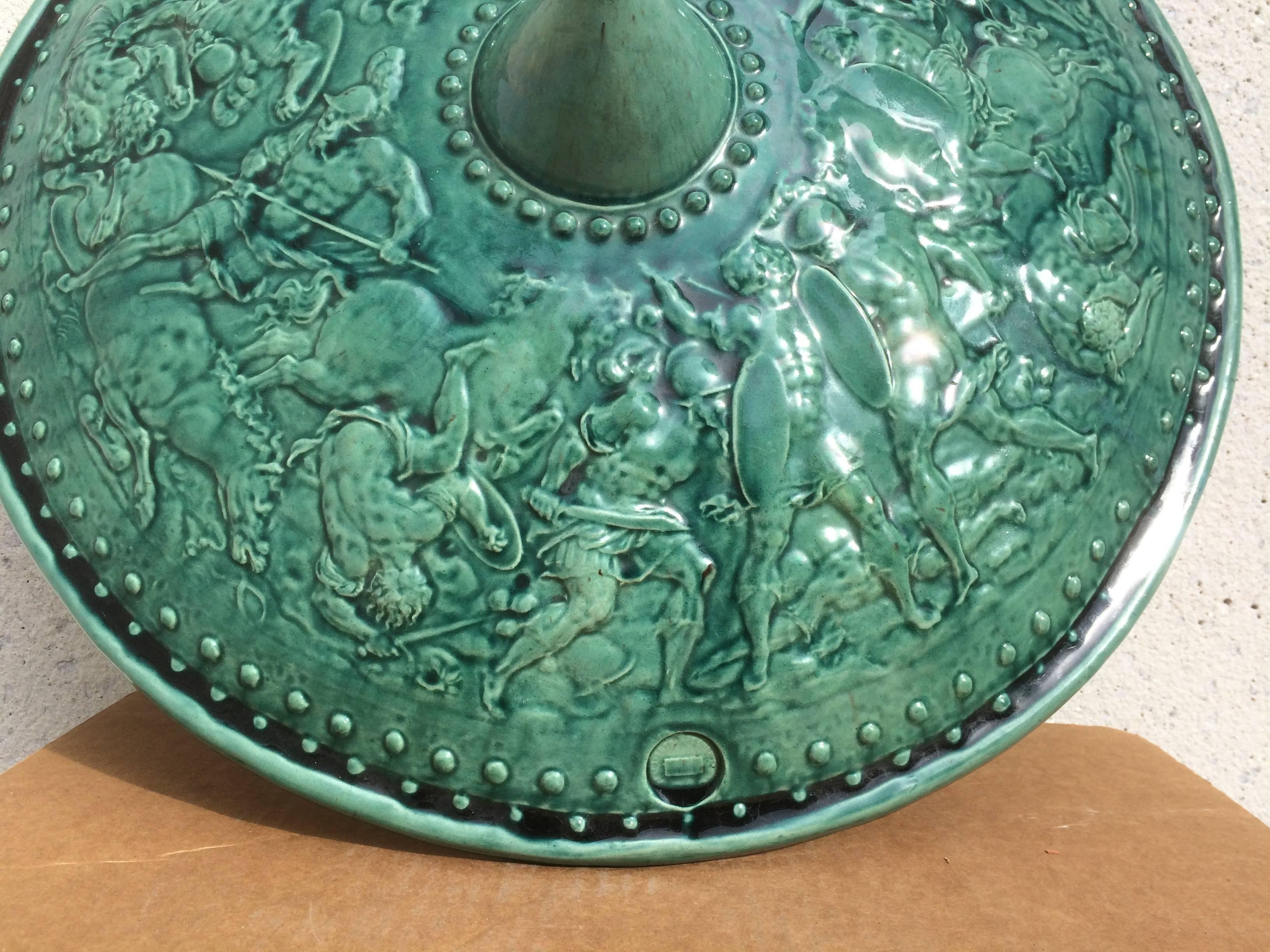 A very fine pair of French majolica ceremonial shields with an unusual turquoise iridescent glaze over incredibly detailed battle scenes. These are most likely copies of a real Renaissance period royal shield. Marked with a stamped lozenge, so far