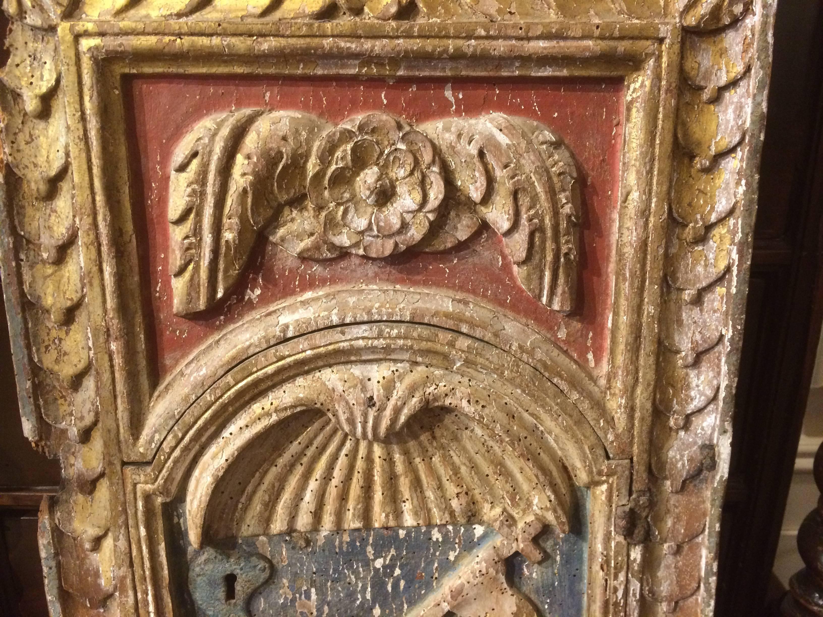 A rare late 17th or early 18th century Italian carved and giltwood tabernacle door retaining much of the original paint. A charming depiction of 'Agnus Dei,' the Lamb of God shown lying down with a cross topped staff with banner tucked under his