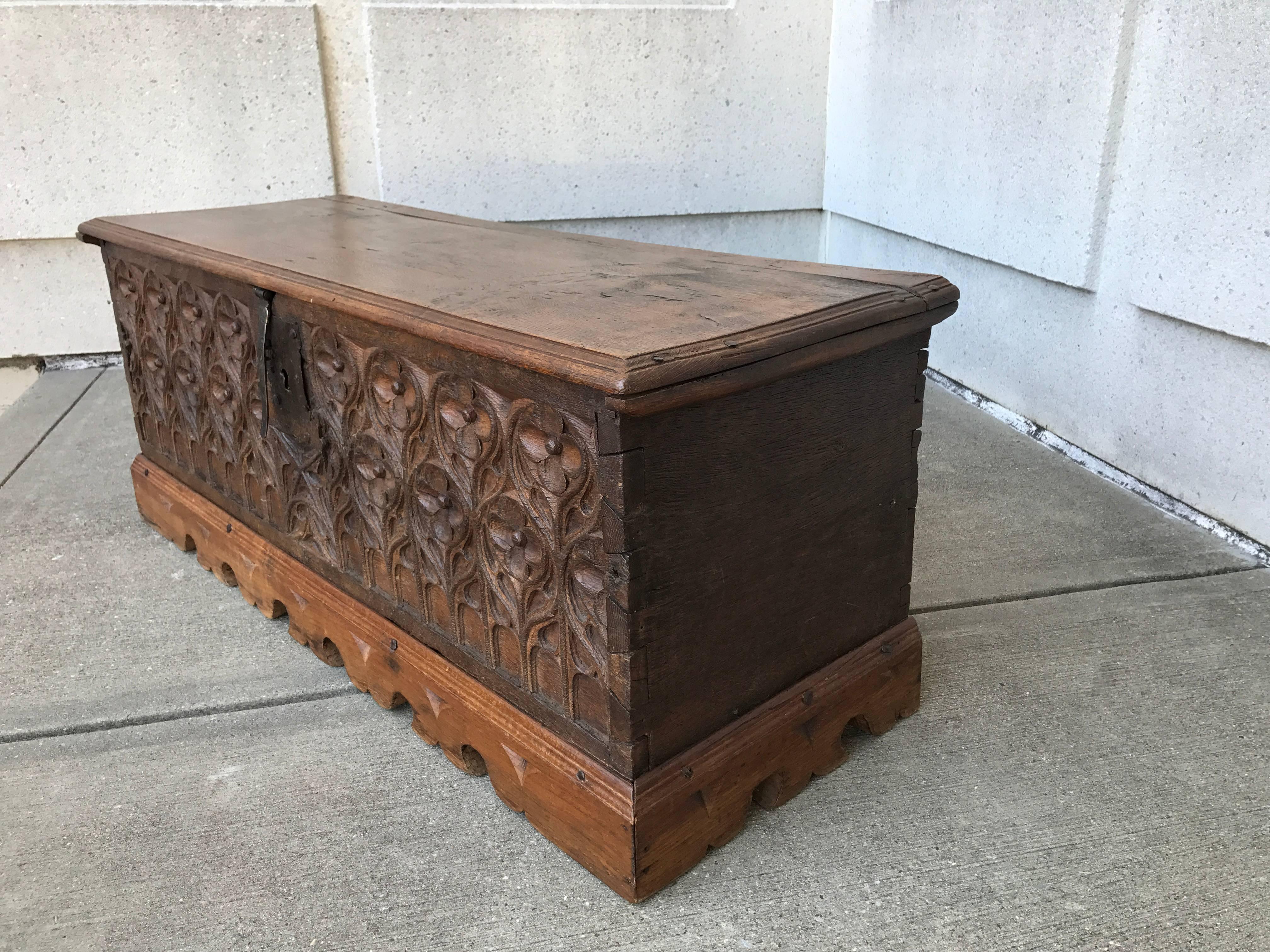 A French oak lift top blanket chest, coffer, cassone with sophisticated carved Gothic tracery front. The body of the chest 16th century. The beautifully carved plinth likely of a later date, 17th or 18th century. Rich honey patina.