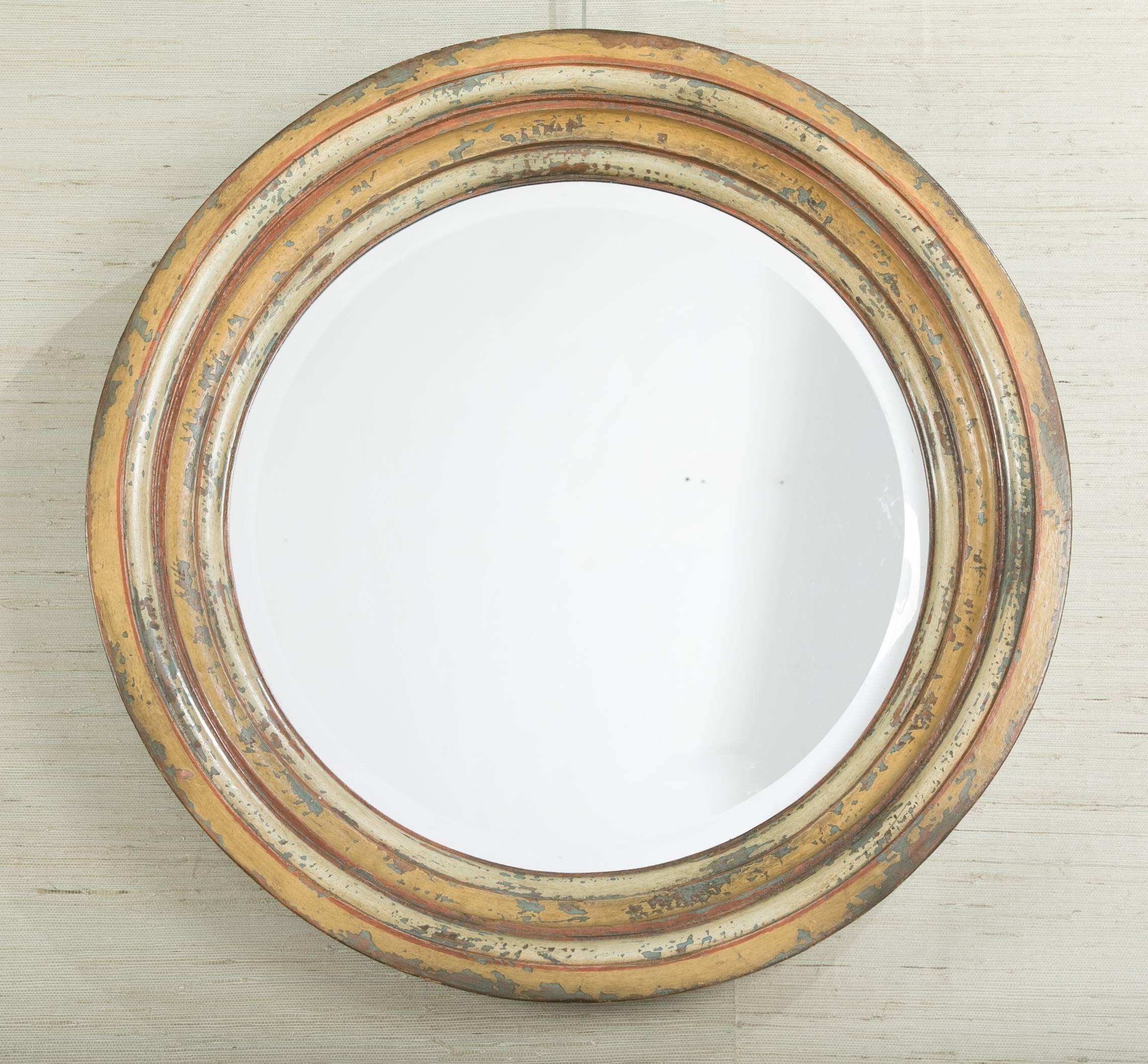 Italian circular mirror with deep carved wood molding and wonderful distressed painted surface that makes the mirror appear to be made of metal. The depth of this mirror, 4 inches, as well at the graduated carved molding and beveled glass give it