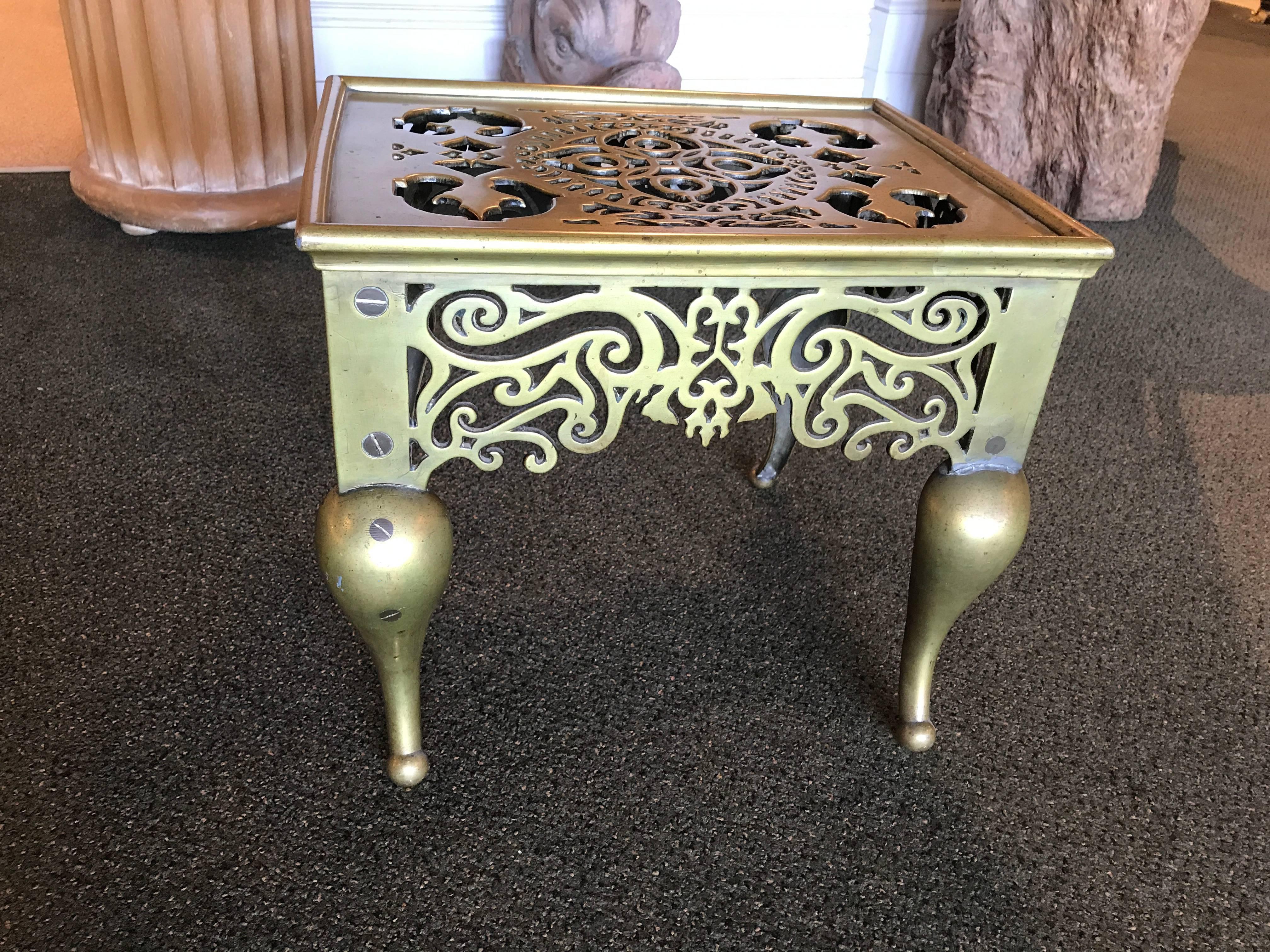 English brass footman, or fireplace trivet with exquisite pierced fret work design. Fully realized in the round, it makes a wonderful and unusual side or drinks table.