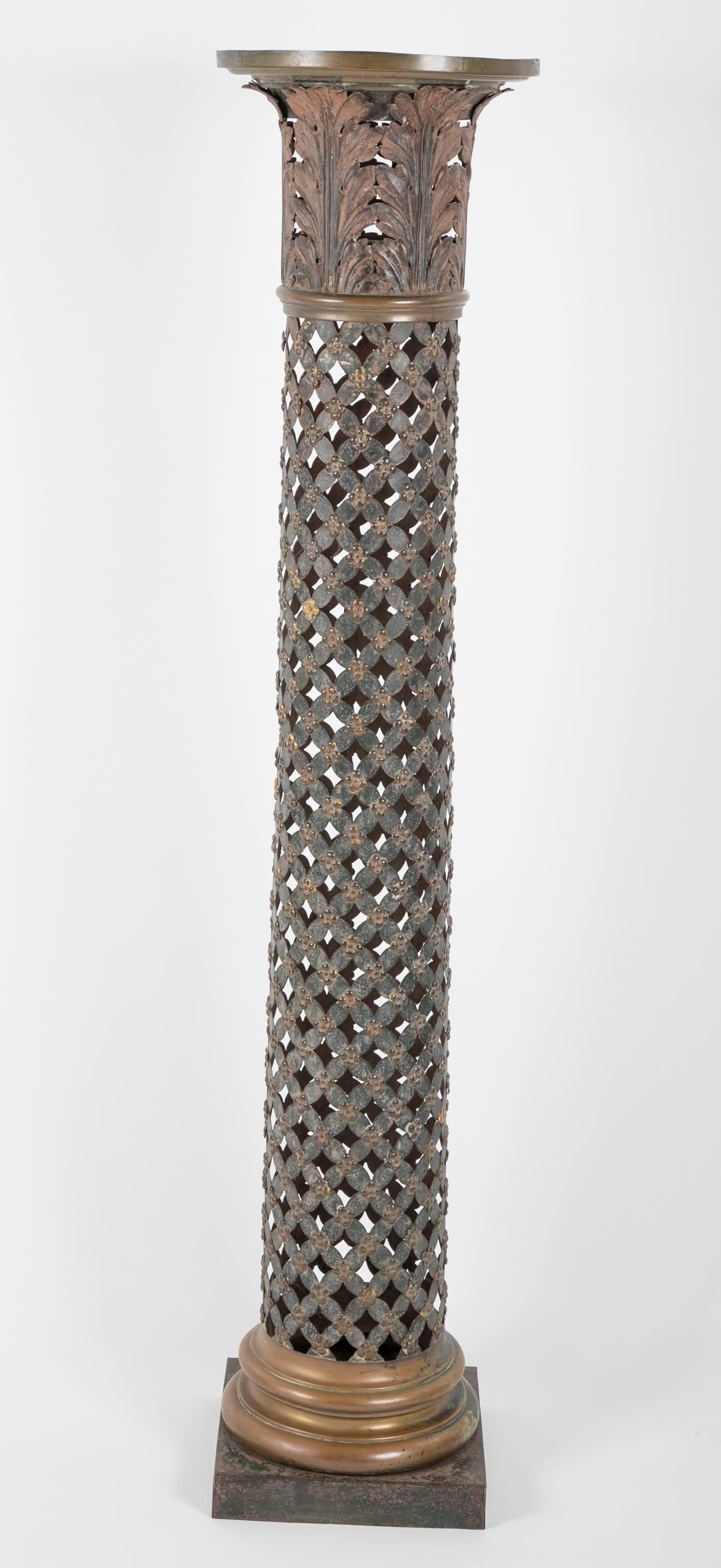 Rara e inusual columna decorativa francesa de tole peinte con capitel de hojas de acanto. Columna en forma de cruz pintada de verde con resaltes dorados, rematada por un capitel corintio. El capitel y la base con molduras de latón. Una gran pieza