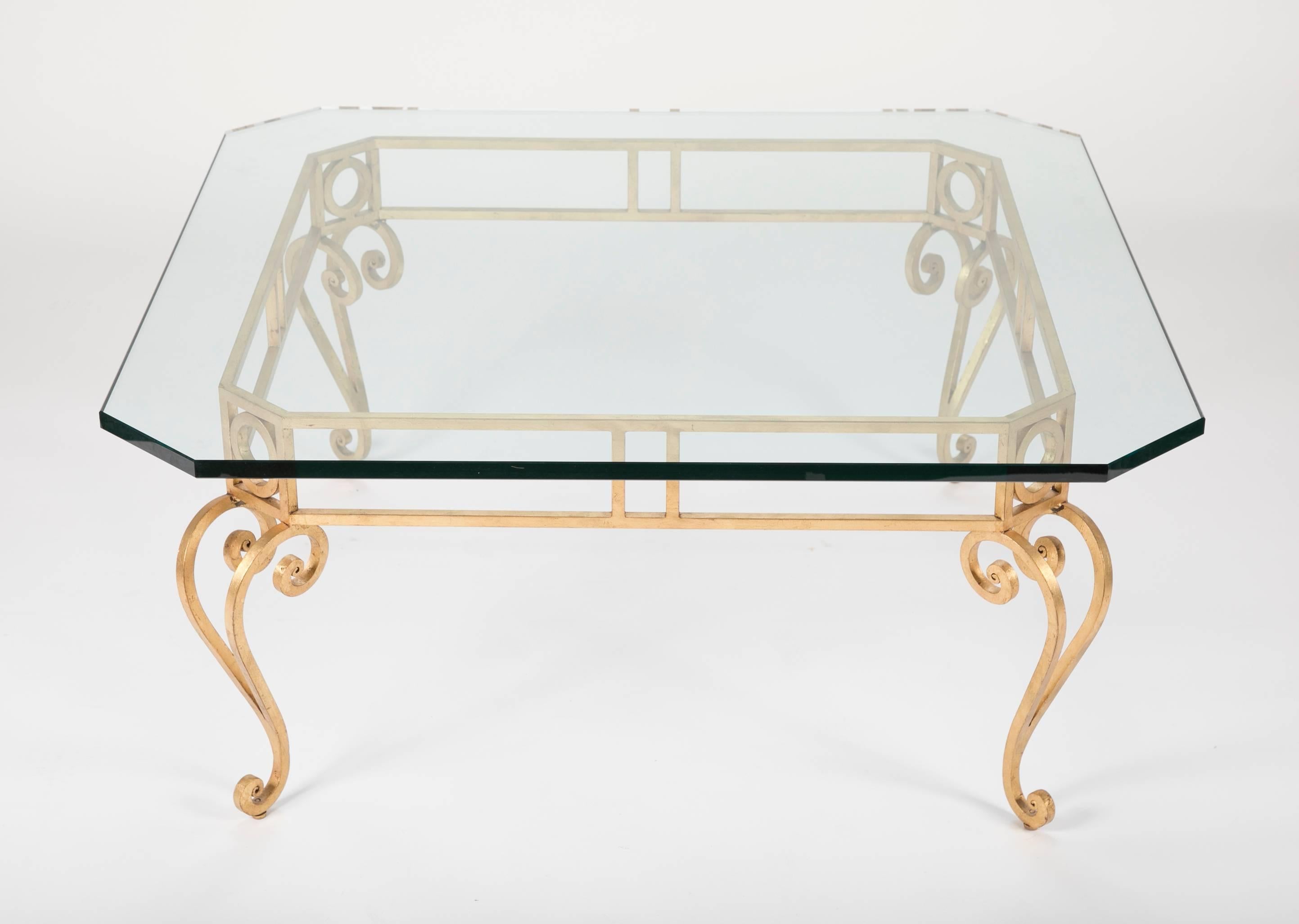 Mid century modern coffee table with a thick square glass top with cut corners on a gilt wrought iron base with cabriole legs. A chic take on Louis XV style, this table has beautiful lines, both modern and quite elegant.