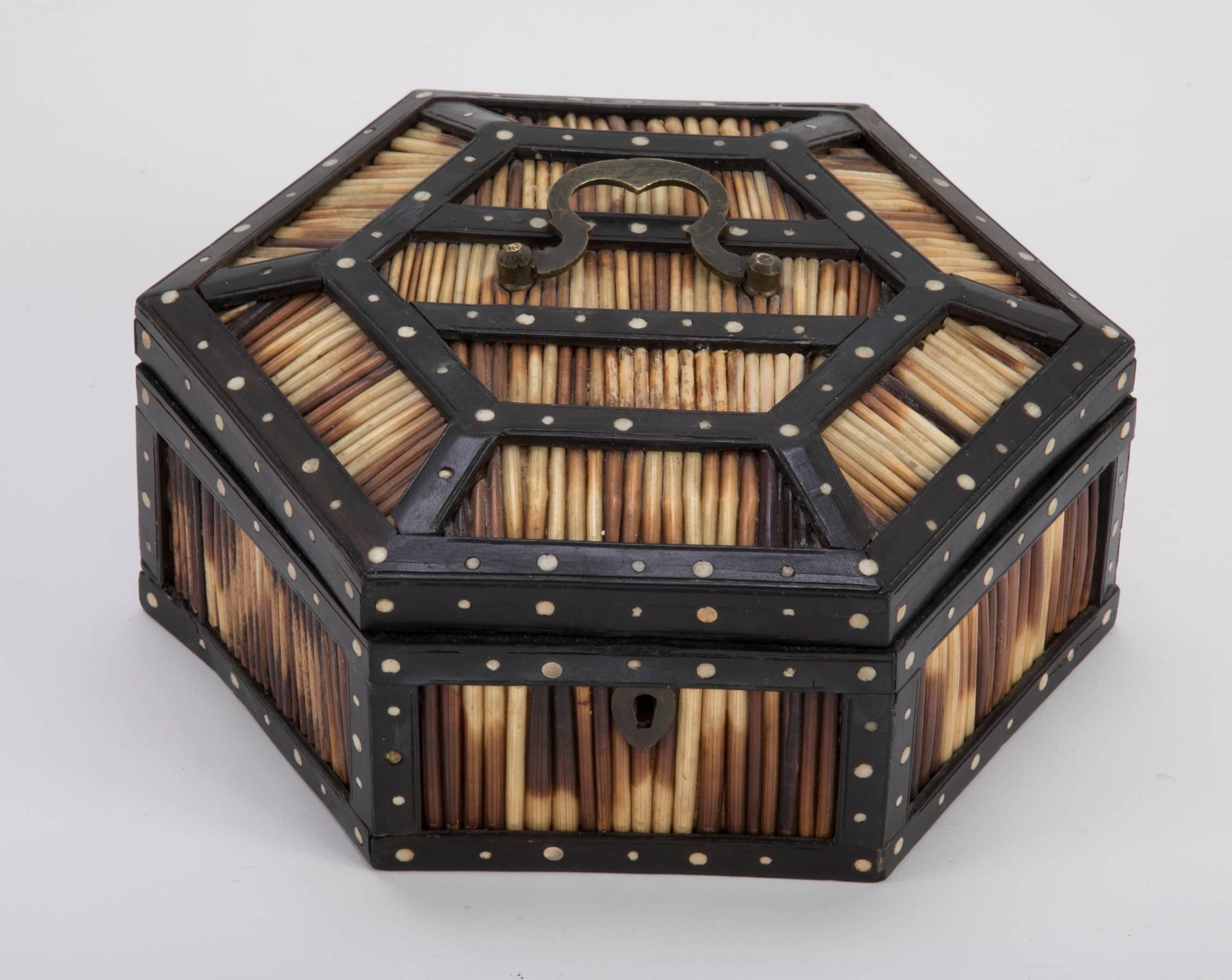 Anglo-Indian hexagonal box of ebonized hardwood inset with disks of bone holding porcupine quills. The inside of the lid decorated with an inlaid hand colored elephant and marked Ceylon. The interior lined with suede. Original brass handle. Ceylon
