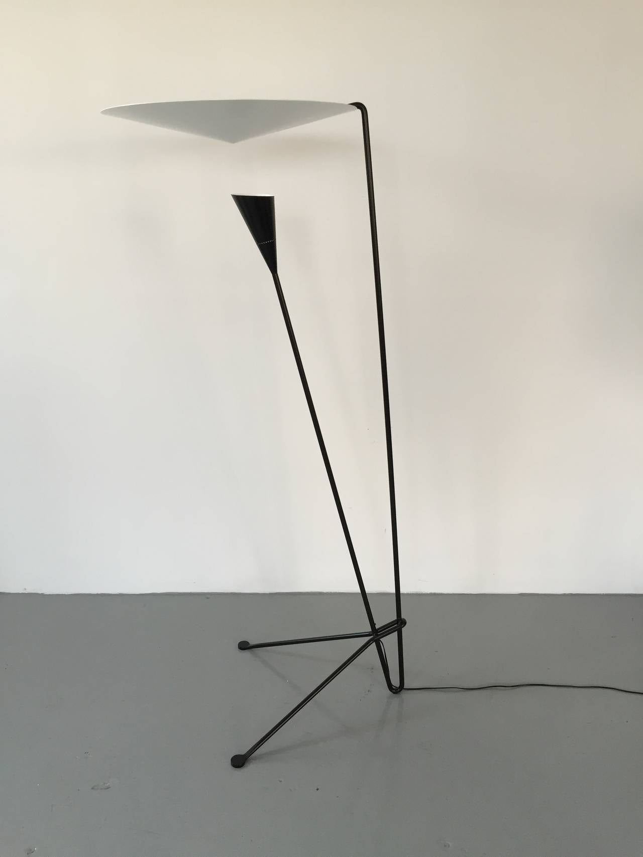 Dynamic lines and an innovative means by which the light is dispersed are signatures of this Michel Buffet lamp. Light shines on the conical disc above from the shade below and is reflected out.

This lamp comes is black and white.

 