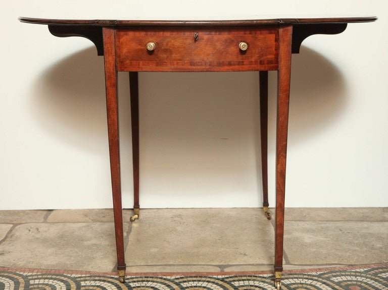 Unusual George III figured mahogany and marquetry pembroke games table, the sliding and reversible top fitted on side with checkerboard and cribbage boards within a satinwood strung and rosewood banded border, the leather-lined well fitted for