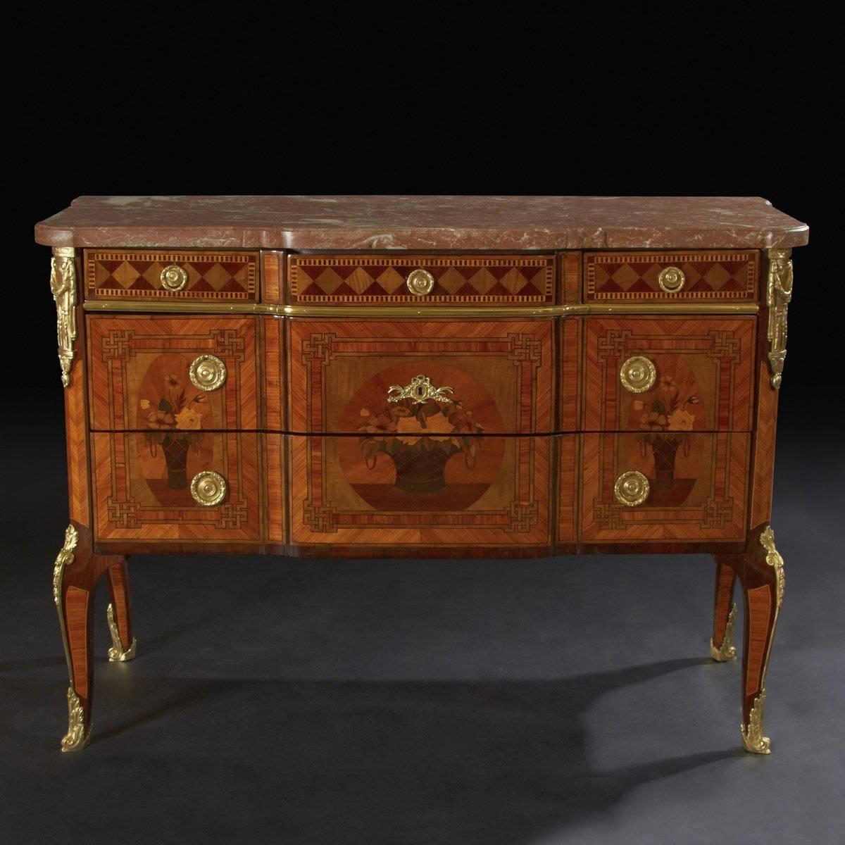 A very fine French Louis XV / XVI Transitional marble top breakfront commode. The five drawer commode is elaborately inlaid with parquetry and marquetry floral baskets. The commode has various ormolu mounts and one stamped. 

France, circa 1830. 
